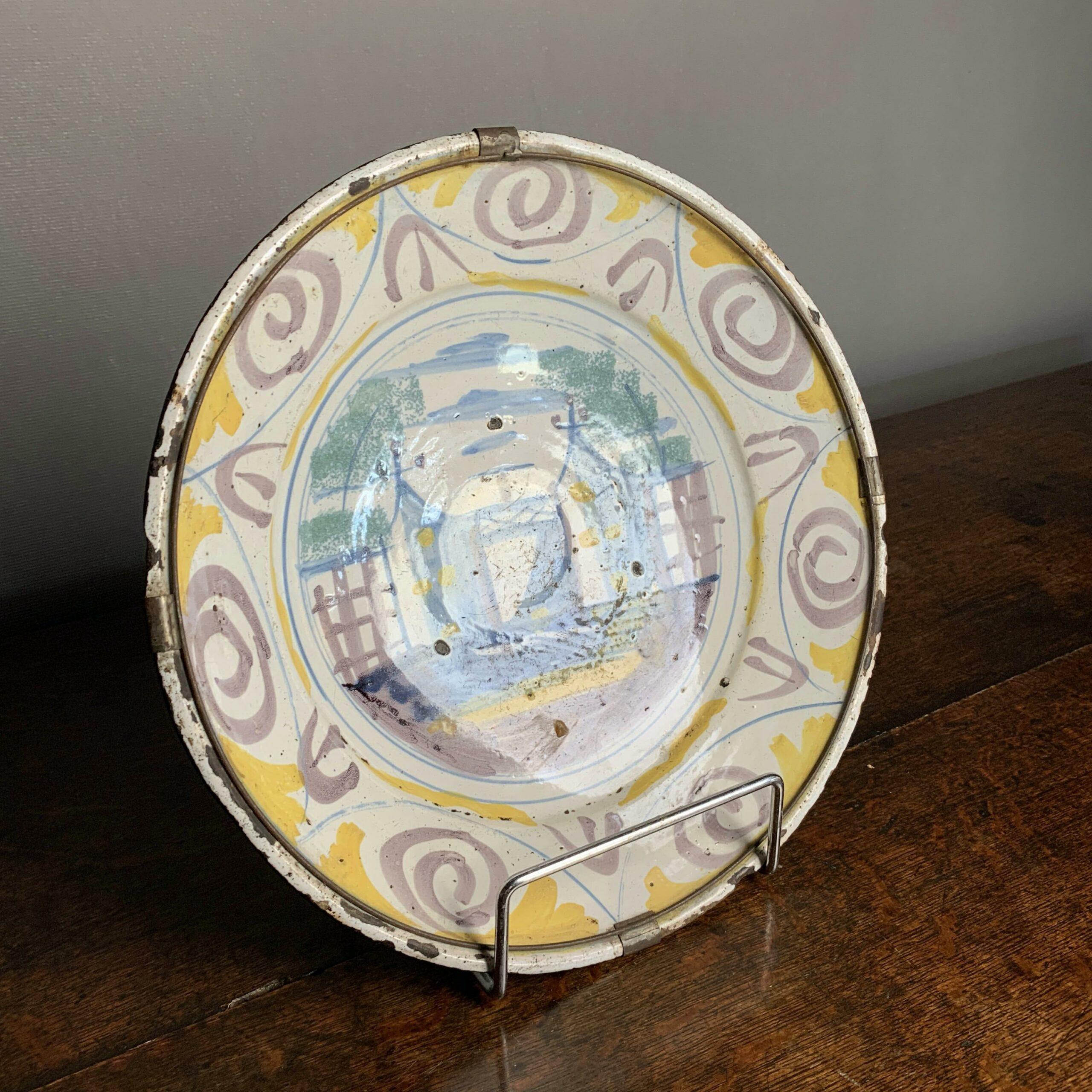 Spanish Charger c1700 with building decoration in the centre and outer decorated rim. Old hanging retained on the back.

Diameter: 30 cm / 12”