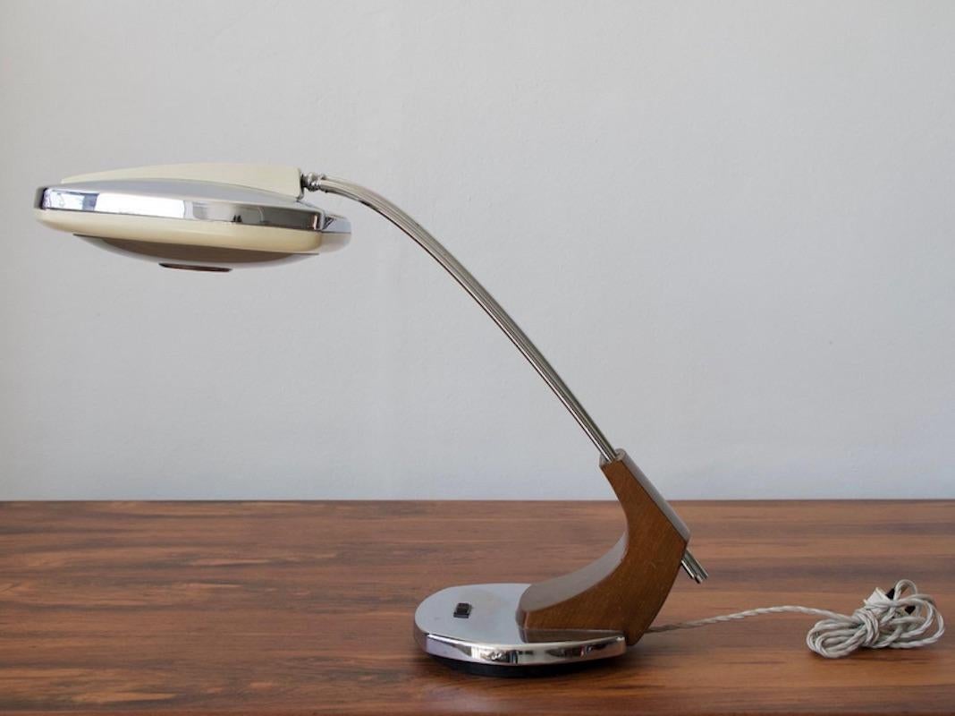 This table lamp was produced in Madrid by Fase in the 1960s. It is a large rotatable and swiveling desk lamp with chromed metal structure, tinted walnut foot detail, white lacquered metal and polished aluminum shade. Two lamps available.
The lamp