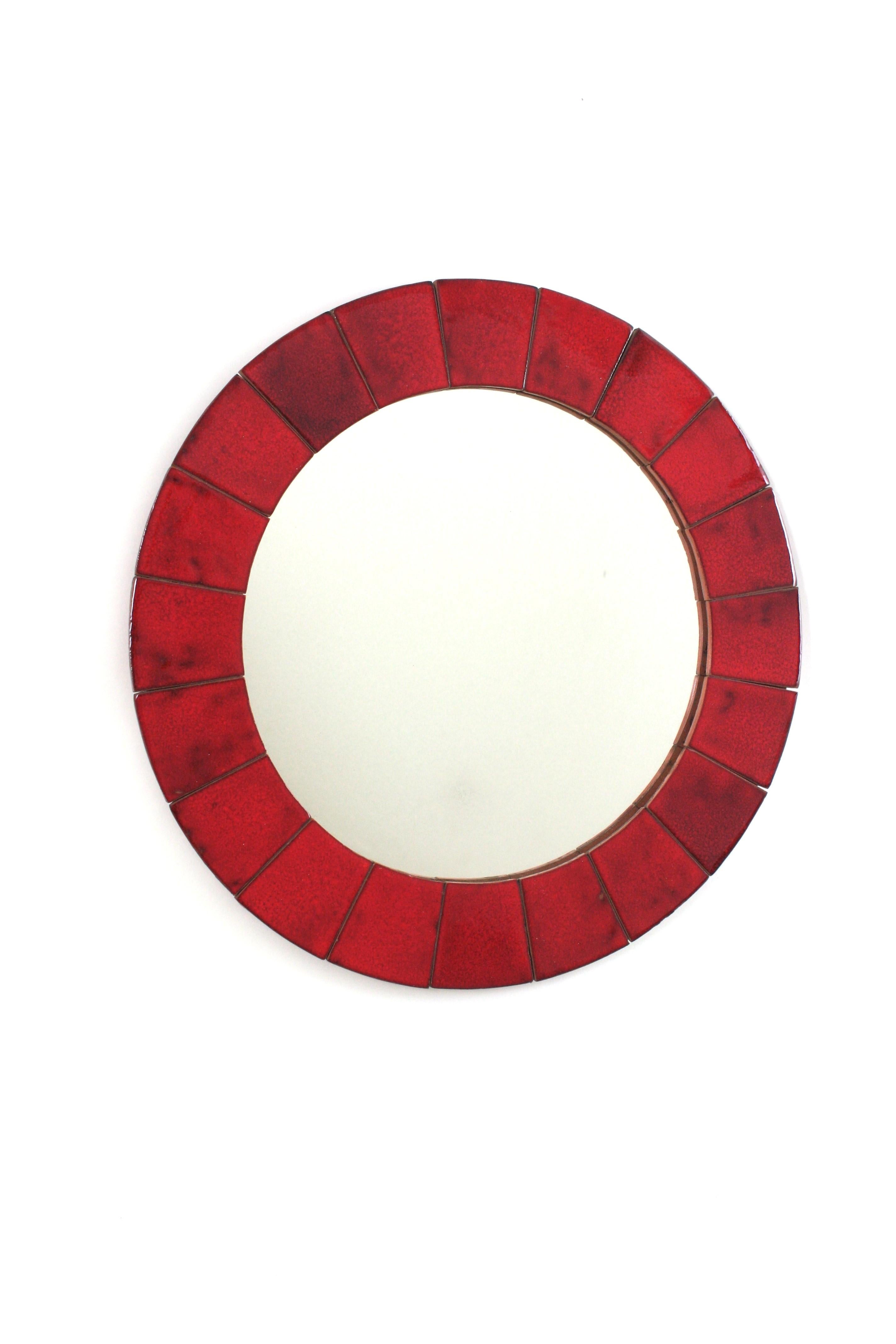 Spanish Red Ceramic Tiles Framed Mirror
Eye-catching ceramic round wall mirror. Maufactured in Spain, 1960s.
Circular shape and large glass mirror surface.
The frame is made of large glazed ceramic tiles in shades of red. 
This colorful mirror has