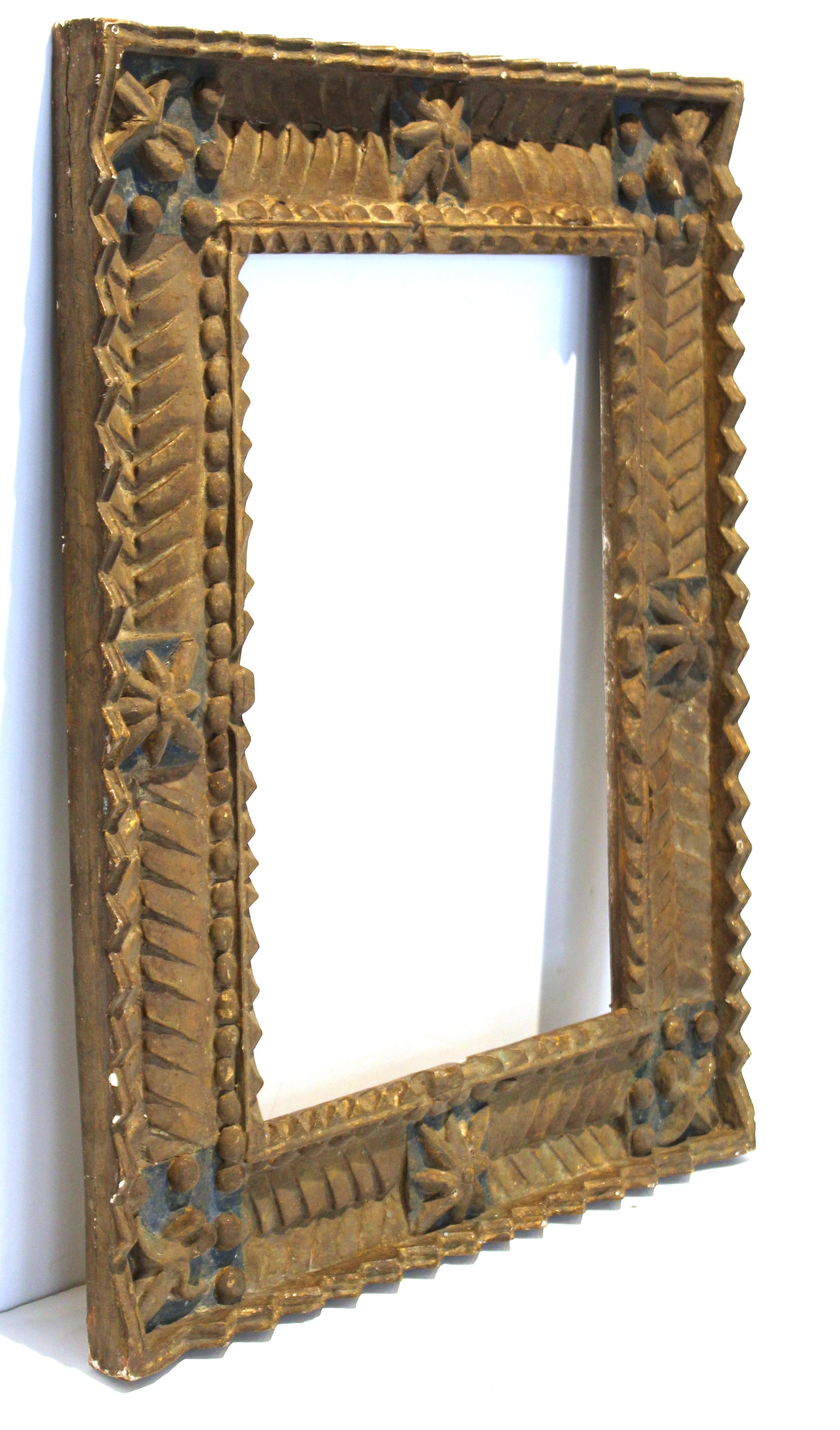 Spanish Colonial Baroque picture frame in wood with deeply carved geometric motif and floral elements in the corners. The piece was made in South America in the 18th century and retains traces of its original gilding and blue paint.
In great