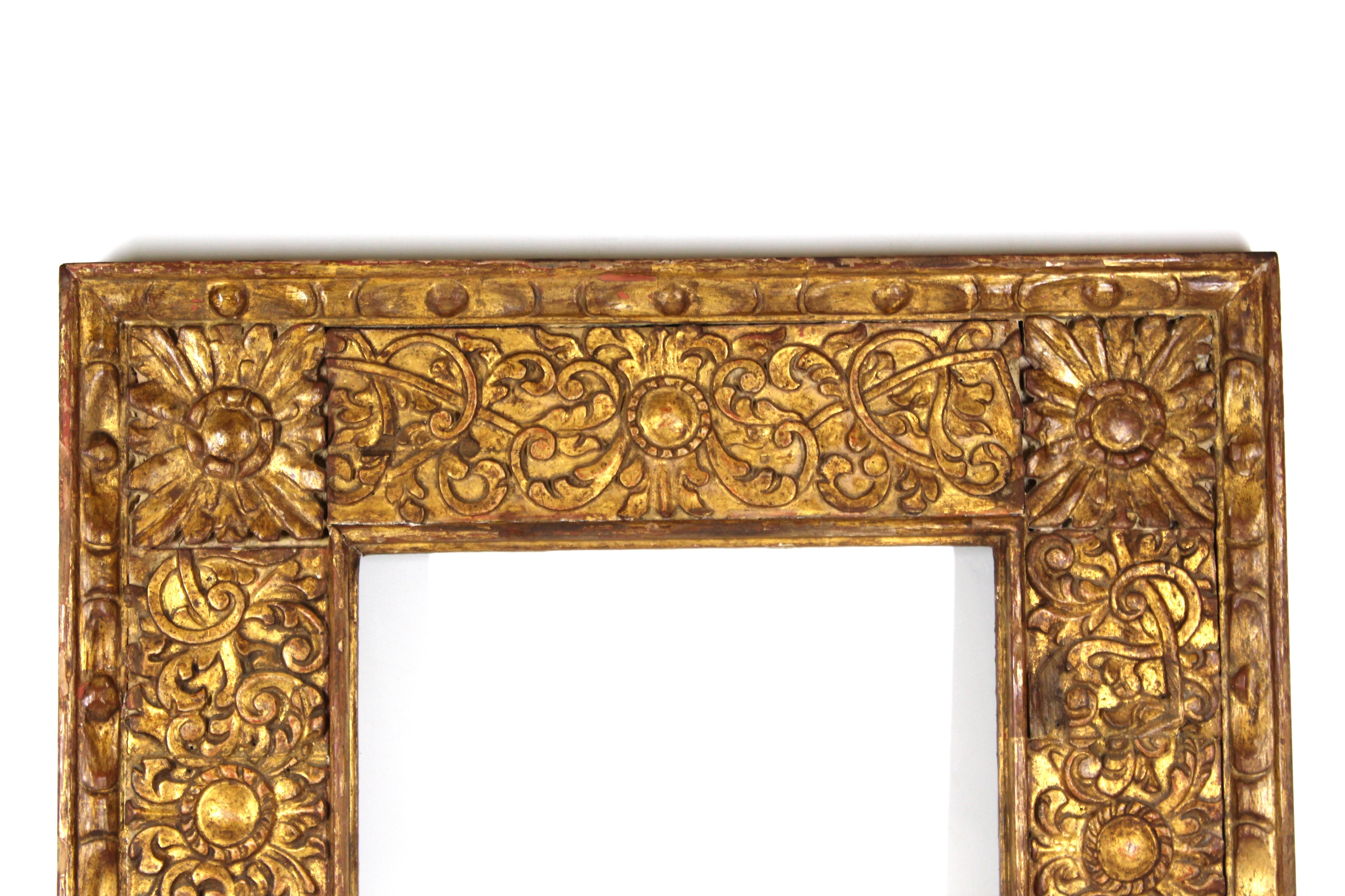 Cadre en bois doré de style baroque colonial espagnol avec un feuillage élaboré lourdement sculpté et doré à la main. Les volutes, feuilles et éléments floraux décoratifs font de ce cadre un exemple exceptionnel de la période baroque, parfait pour