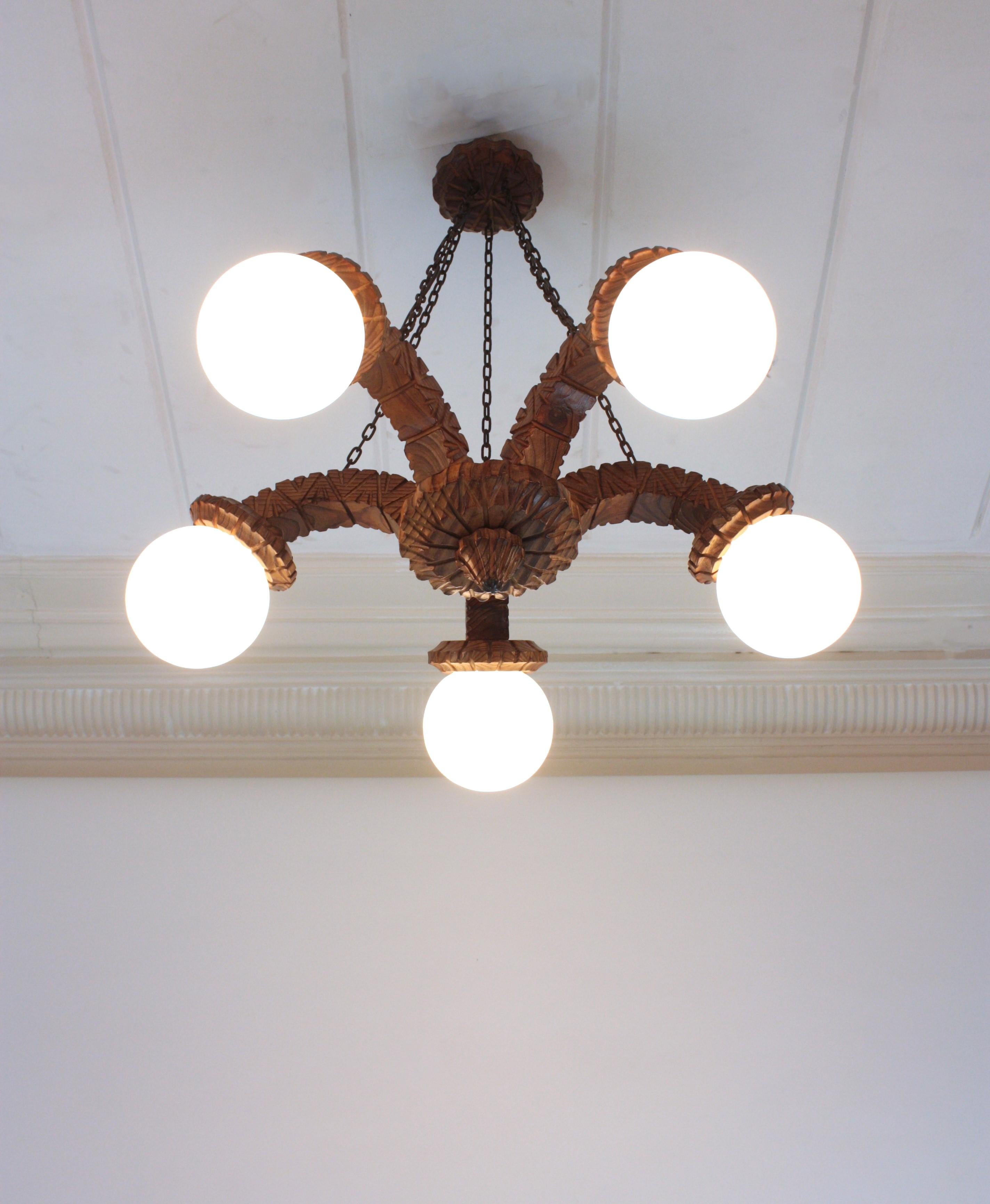 Spagnolo Lampadario Coloni spagnolo a cinque bracci in legno intagliato e vetro opalino, anni '50 in vendita