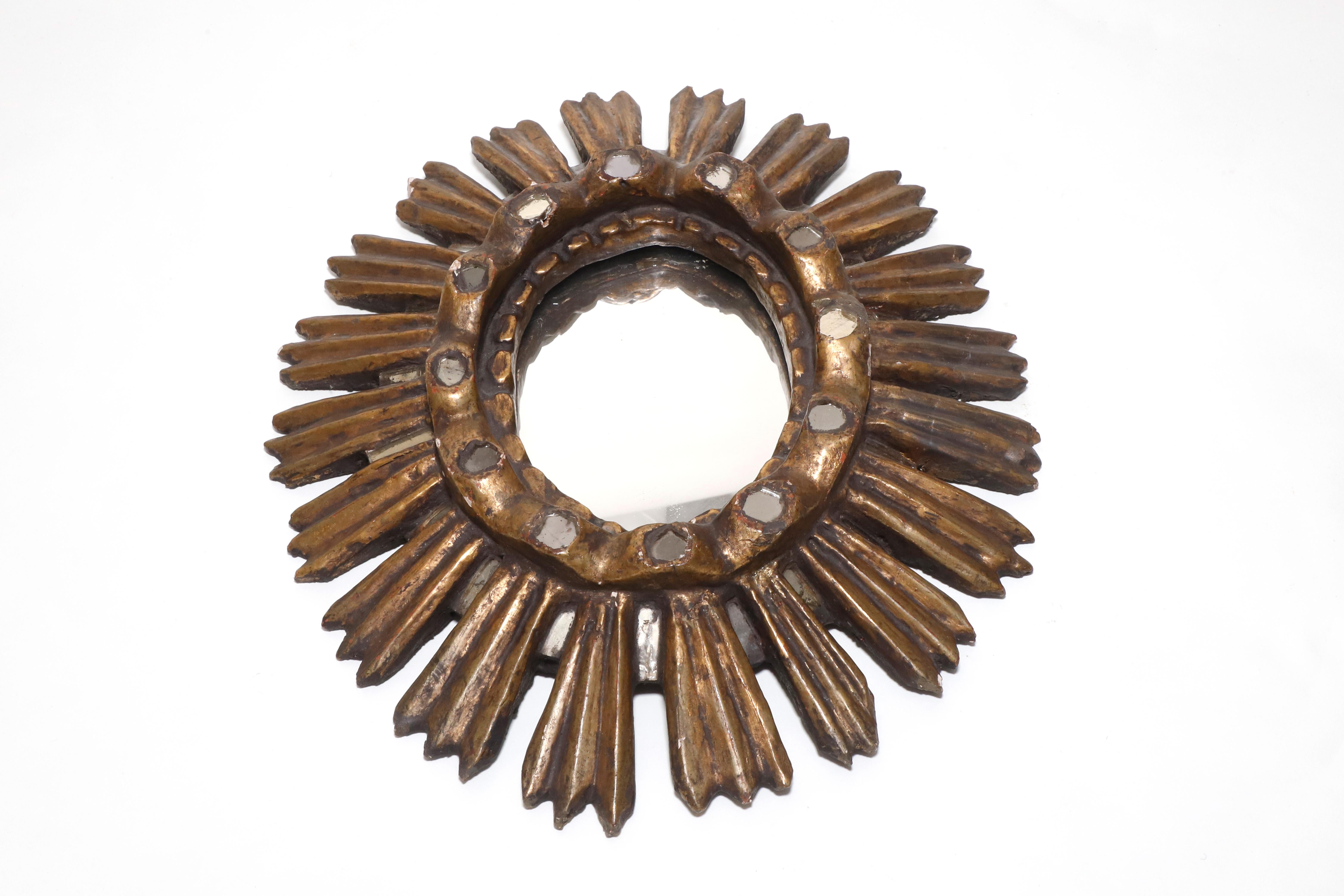 Spanish Colonial giltwood sunburst oval mirror. Beautiful hand carved piece with small circled mirror details arround the the main center oval mirror plate. Circa 1940s. Natural Patina.

Property from esteemed interior designer Juan Montoya. Juan