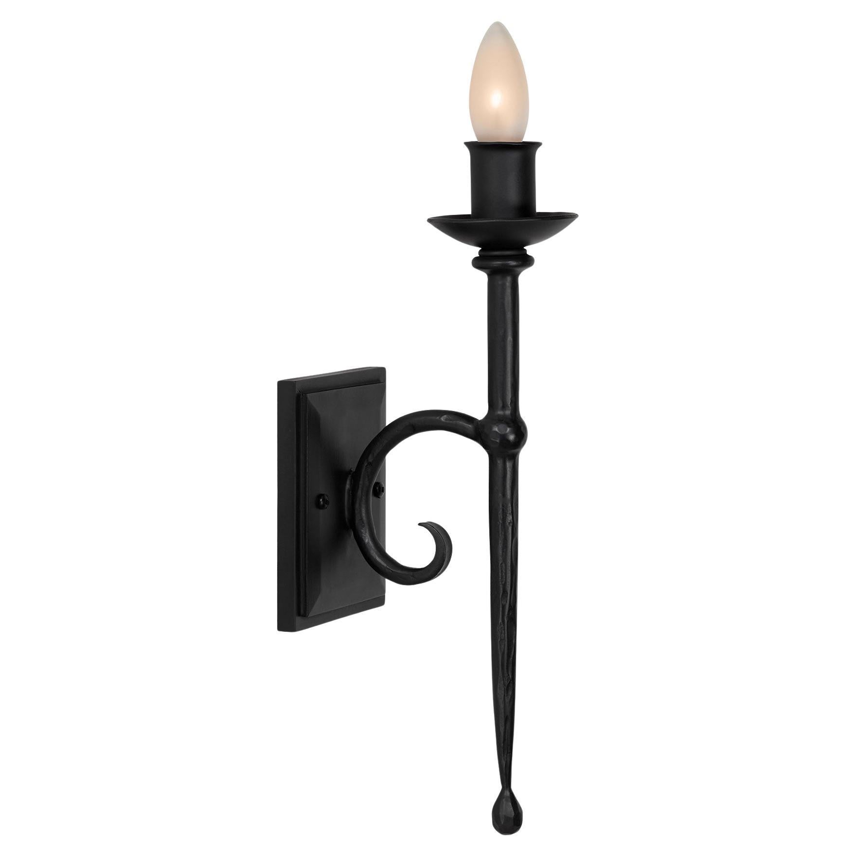Elegant wall sconce with gentle tapering, a beautiful double curved c detail and classic torchiere details. Hammered texturing and a rich waxed finish gives this wrought iron fixture a softer look. Available in SBLC Brown Waxed Finish and SBLC Black