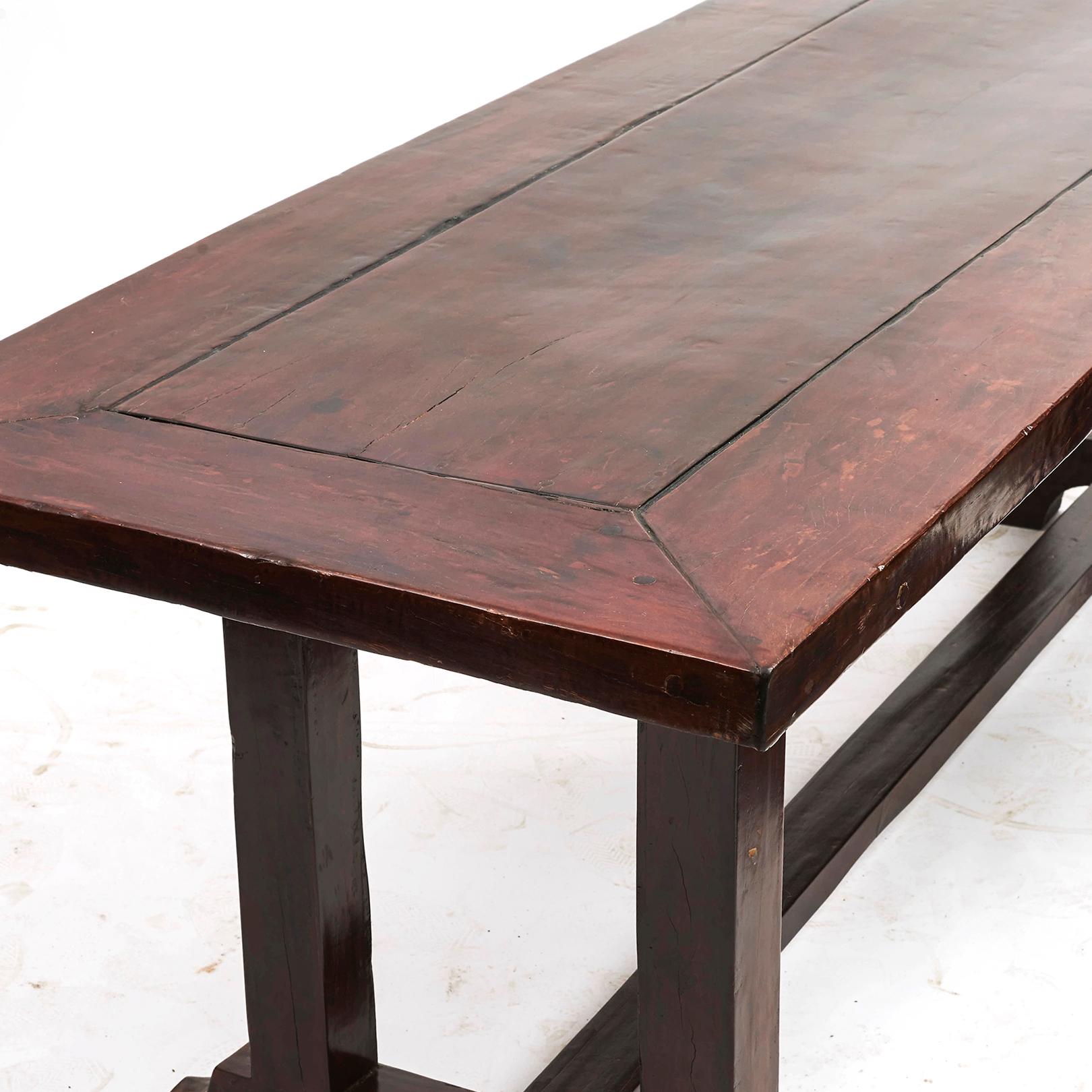 Long Spanish-colonial dining table made of molave hardwood, a tropical hardwood type.

Tabletop is made of one piece of wood bordered by a thick frame. Square legs and trestle base.
The table has a naturally beautiful patina and finish,
