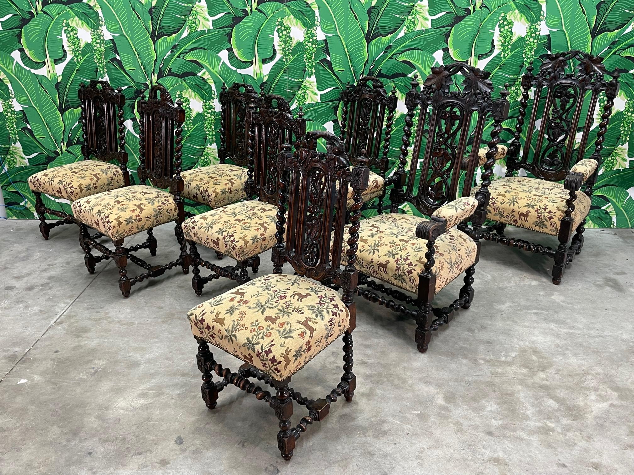Set of 6 carved wood dining chairs in Spanish colonial style. Heavy and substantial with an ebony finish. Thick cushioning and padded arm rests. Good vintage condition with imperfections consistent with age, some small finial balls no longer present