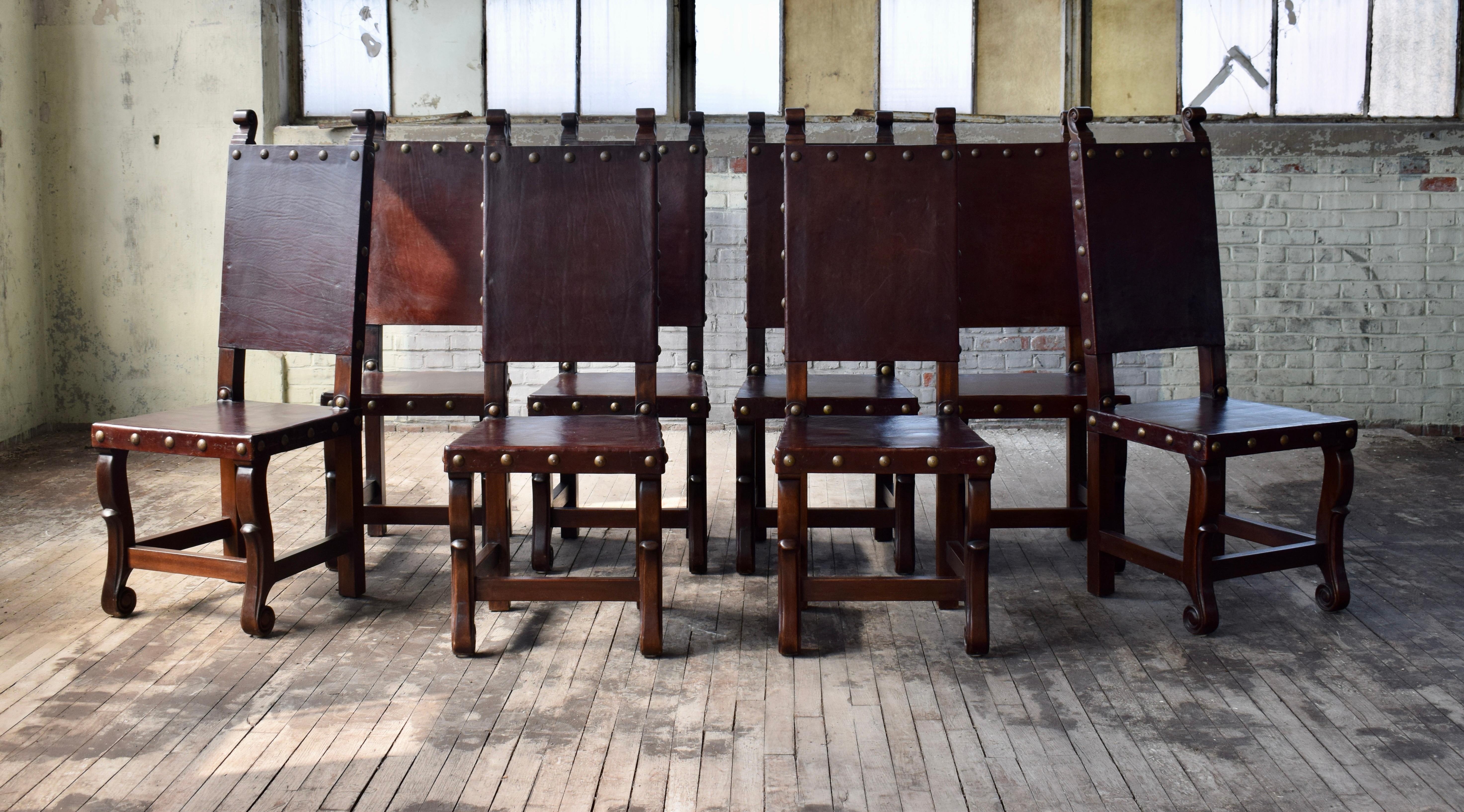 Satz von 10 geschnitzten Holzstühlen mit dicken Ledersitzen und Rückenlehnen, die mit Messingnagelköpfen im spanischen Kolonialstil verziert sind. Wunderschöner, felsenfester Zustand und sofort einsatzbereit.