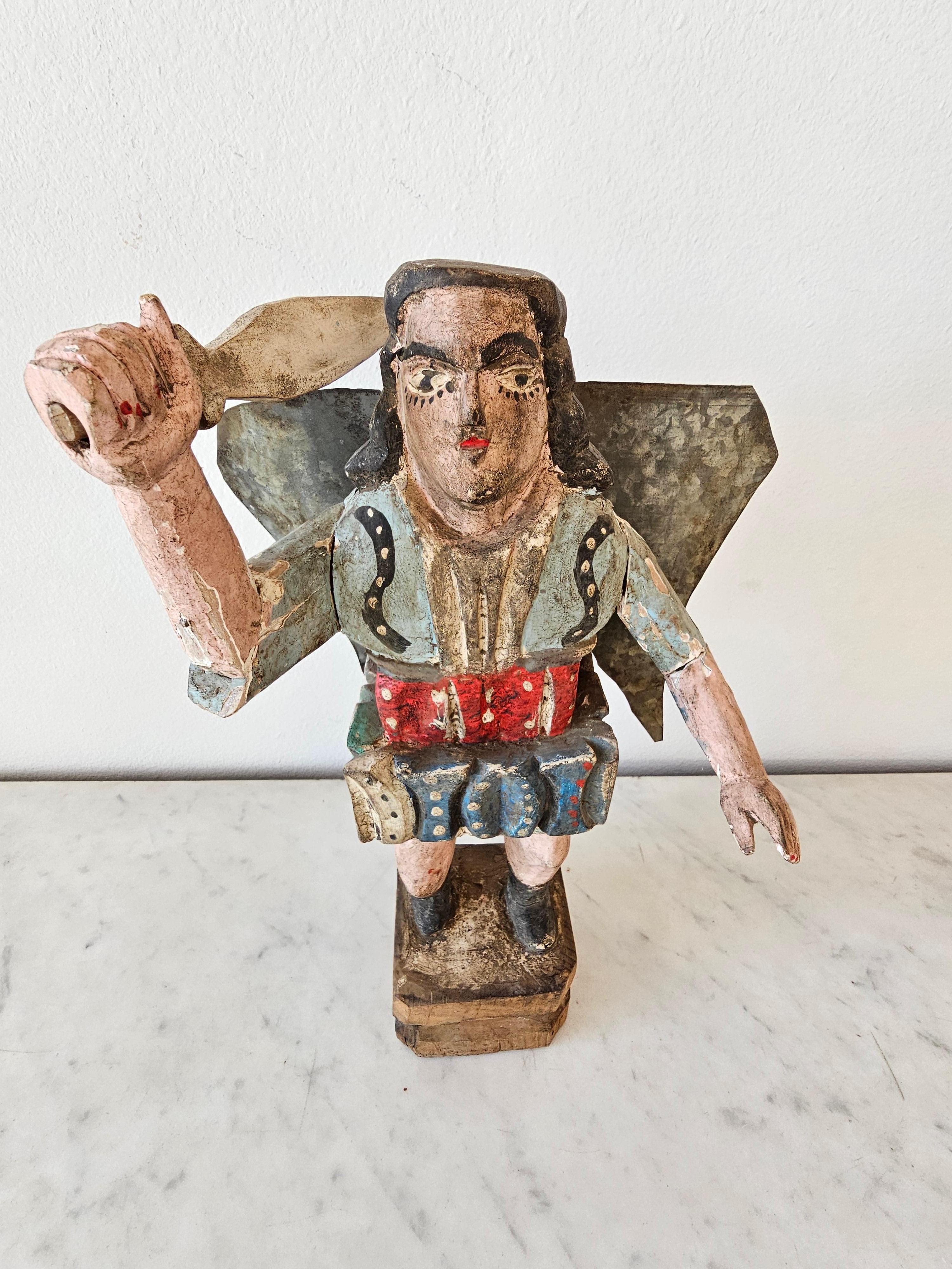 A large vintage Spanish Colonial style Mexican religious folk art carved wood santo figure - bulto carving.

Mid-20th century, Mexico, primitive hand-crafted construction, one-of-a-kind, likely depicting San Miguel Arcángel (Saint Michael the