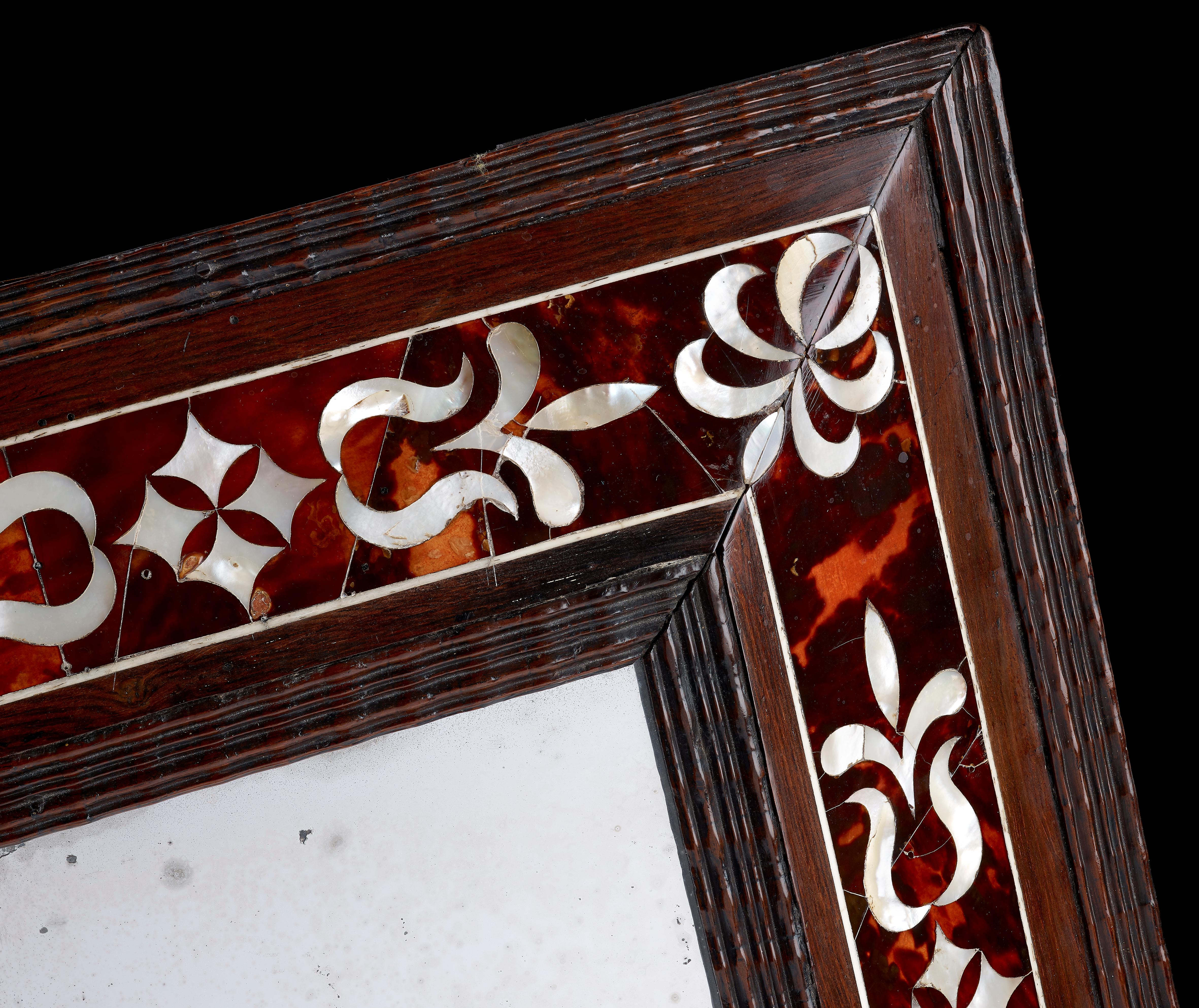 A Spanish Colonial mirror, rosewood with tortoiseshell and mother of pearl decoration; 17th century. 

Measures: 37cms tall by 33cms wide.