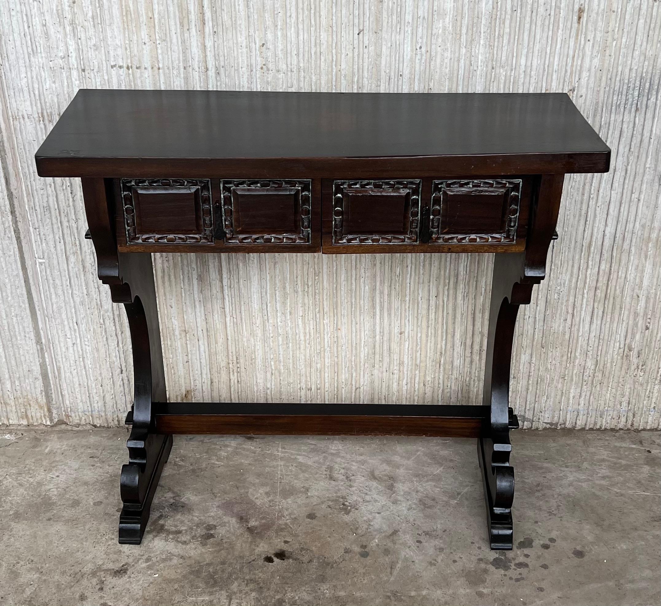 Spanish colonial narrow console table with two carved drawers
This piece has a two-pedestal legs with an awesome carved. 

We have a matching piece you can see in the last picture.
 