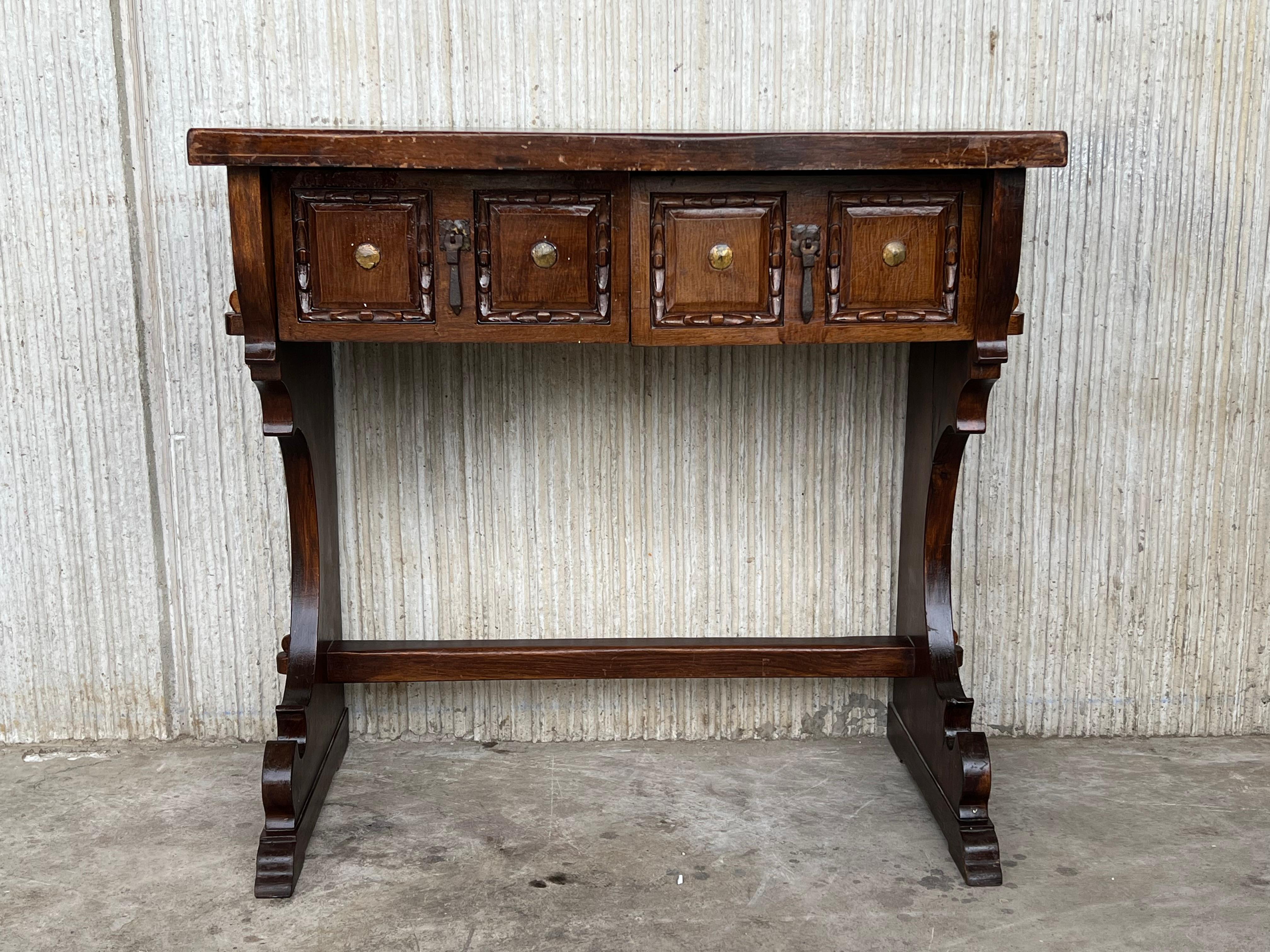 Spanish colonial narrow console table with two carved drawers This piece has a two-pedestal legs with an awesome carved.