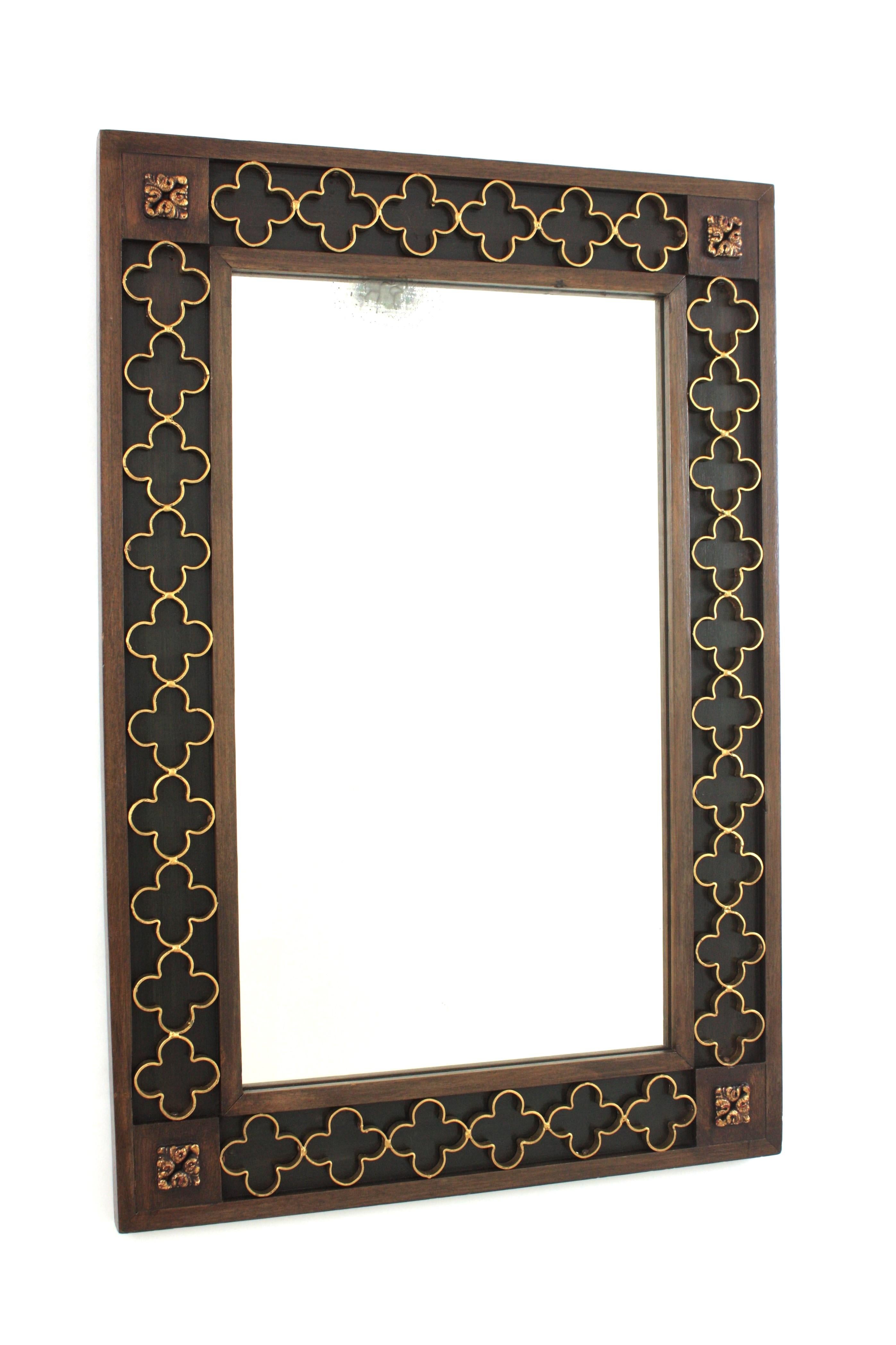 Grand miroir rectangulaire en bois de style néo-espagnol avec rosettes en fer doré, Espagne, 1950-1960.
Magnifique cadre rectangulaire avec des détails sculptés dans les coins. Il présente un cadre encastré avec un fond peint en vert foncé et un