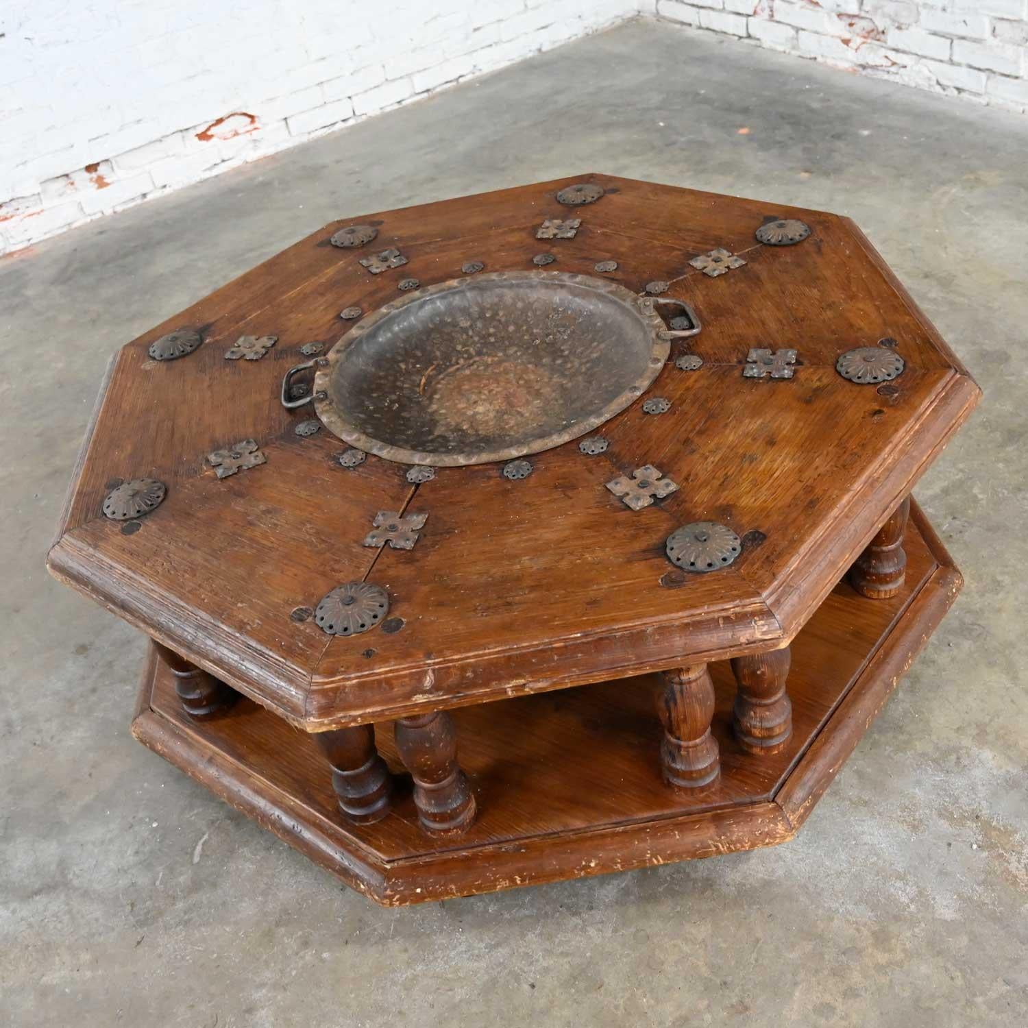 Fabulous Spanish Colonial Revival rustic distressed 2-tiered octagon Brazier coffee table with hand hammered steel rustic center bowl and tabletop details style of Artes De Mexico. Beautiful condition, keeping in mind that this is vintage and not