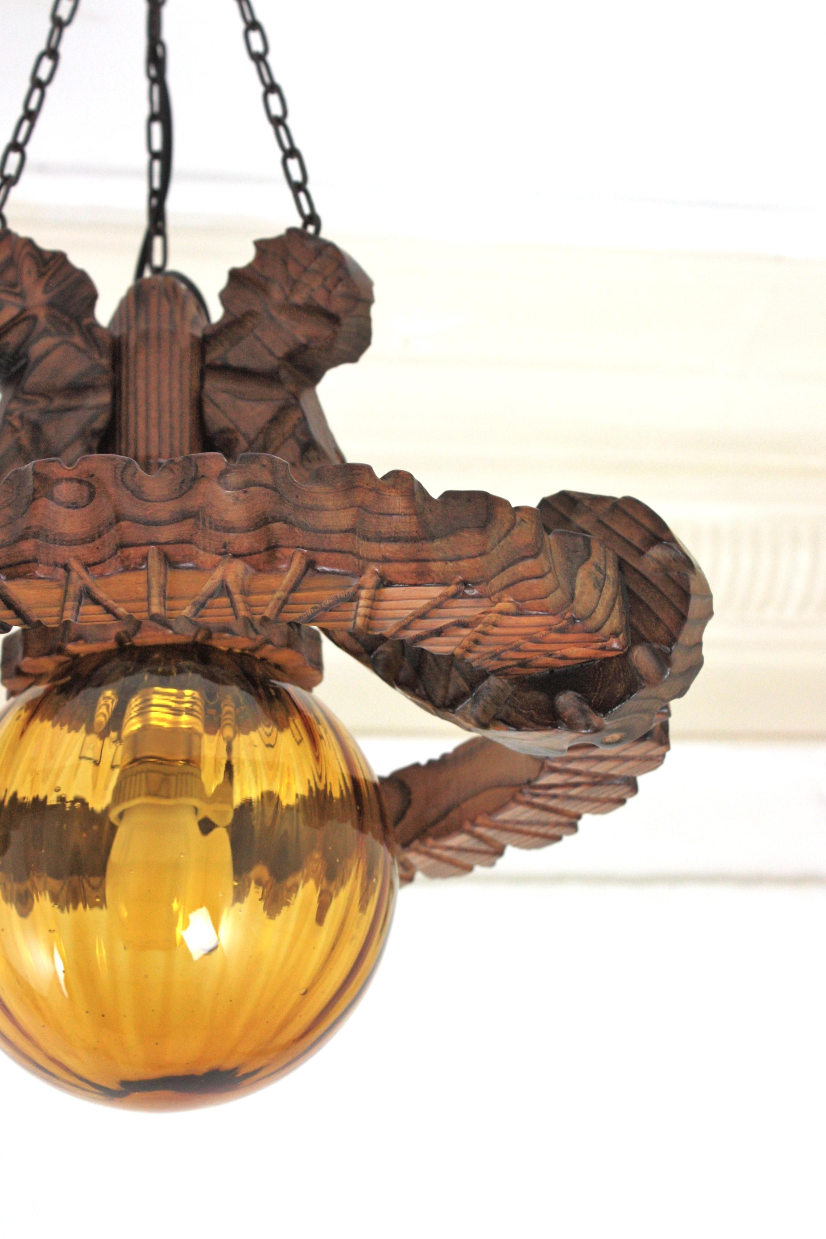 Spanish Colonial Ring Pendant Light Fixture in Carved Wood & Amber Glass, 1950 Tallado en venta