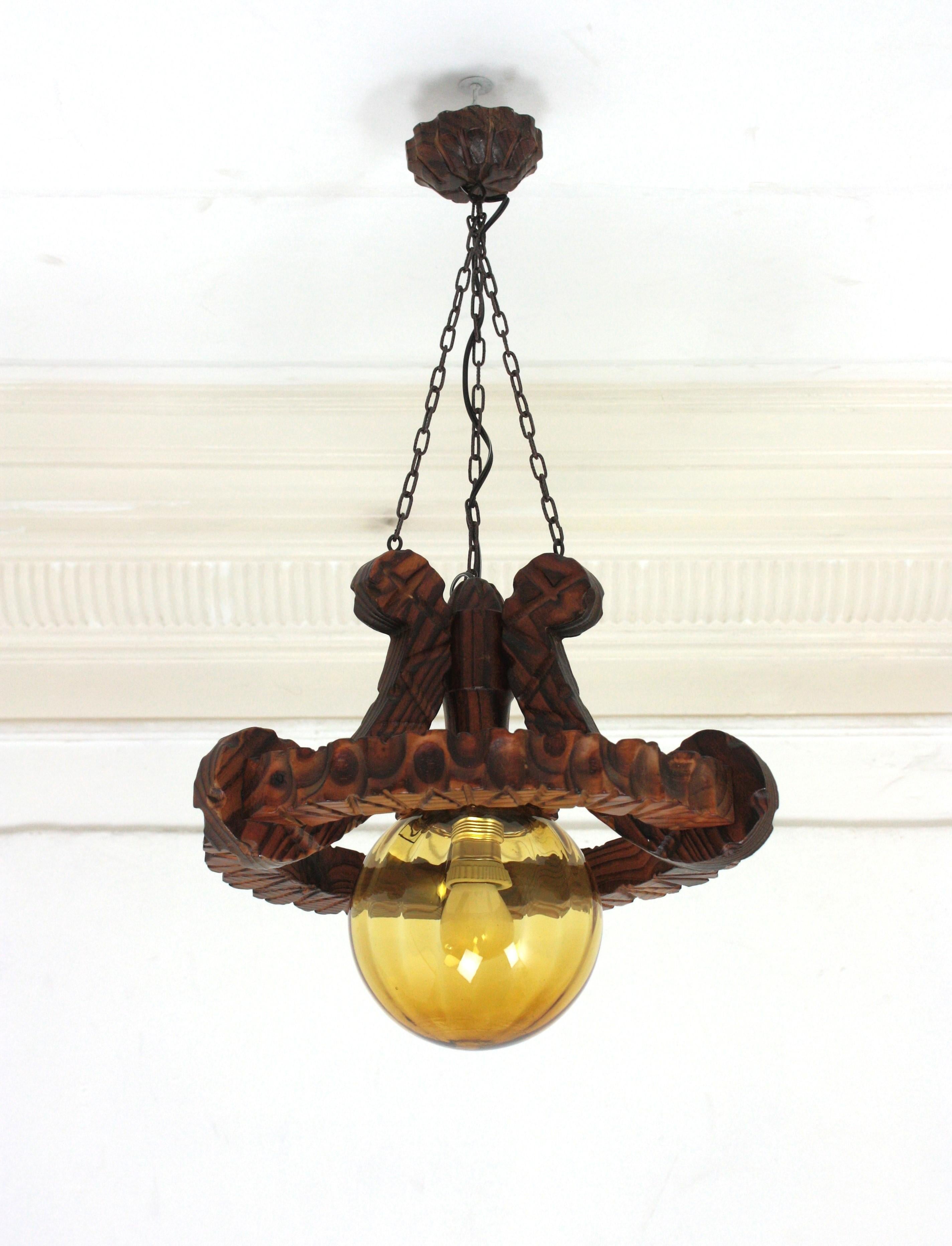 Spanish Colonial Ring Pendant Light Fixture in Carved Wood & Amber Glass, 1950 Vidrio en venta