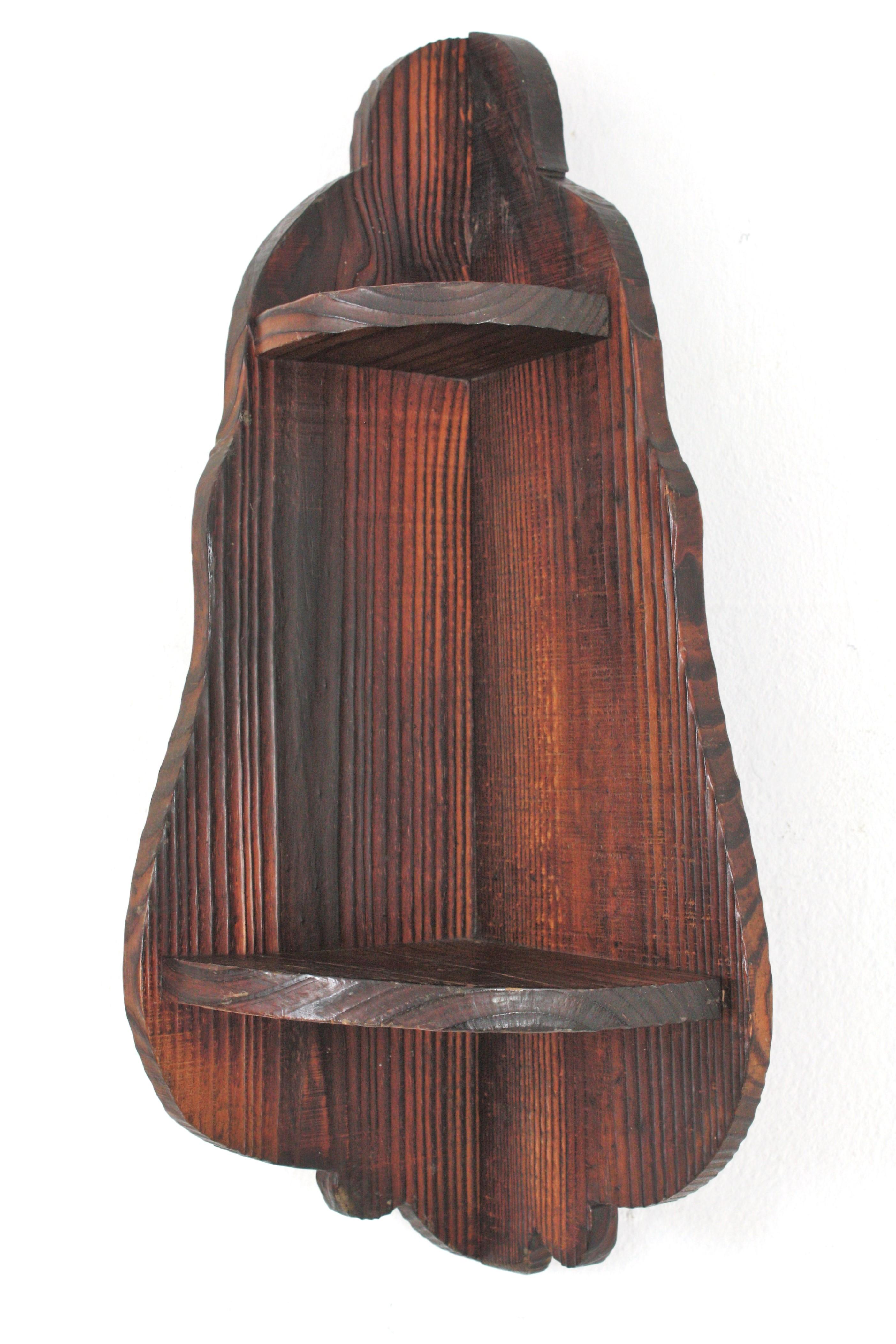 Estantería esquinera de madera colonial española, años 40
Especiero o pequeño estante esquinero de pared de pino tallado a mano.
Esta estantería tiene detalles festoneados y tallados, una balda más grande en la parte inferior y otra más pequeña en