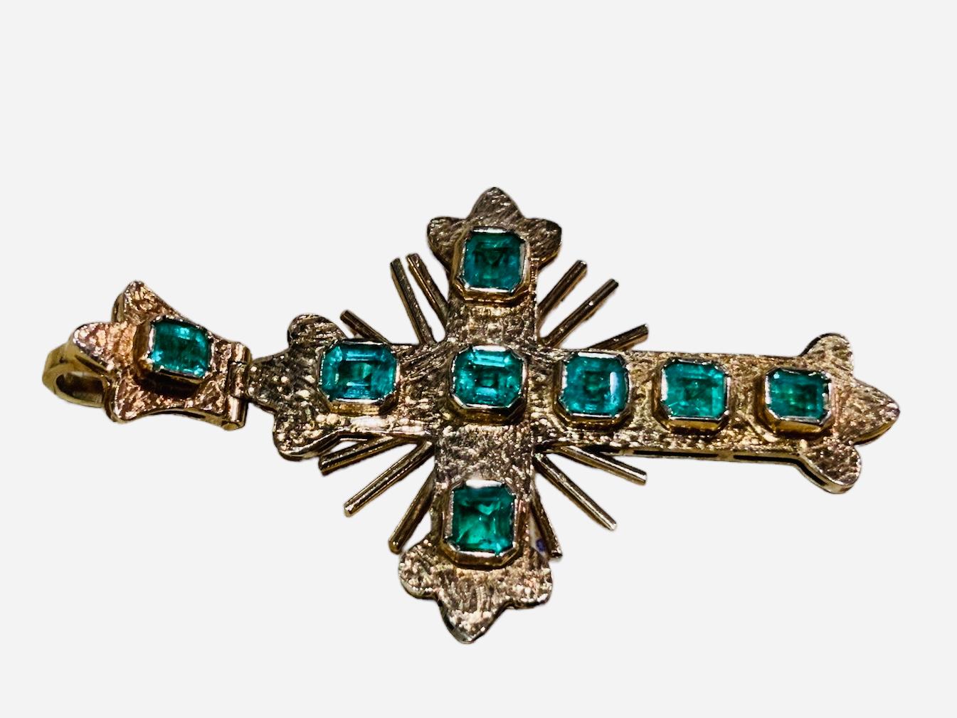 This is an 18k yellow gold and emerald cross pendant. This Spanish Colonial style cross pendant has eight Colombian emerald cut emeralds weighing 2.  carats. They are mounted in 18k gold bezel setting. The weight of the cross is 8.9 grams.