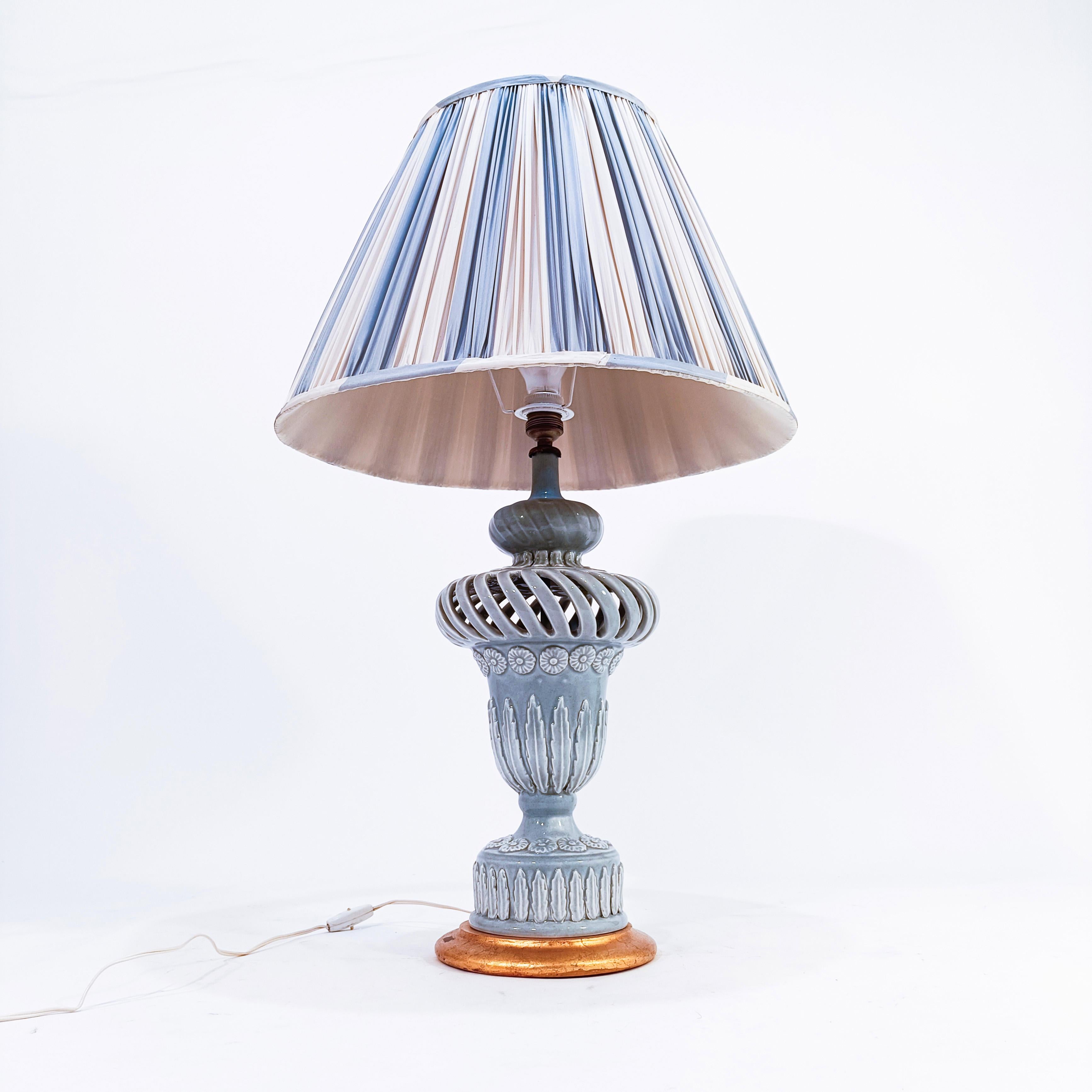 Large Spanish table lamp from Manises, 1960s. Handmade and molded ceramic base, glazed in pale blue color. Elegant design in the shape of an amphora or vase, with applications of reliefs of leaves, flowers and plant motifs. Wooden base with gold