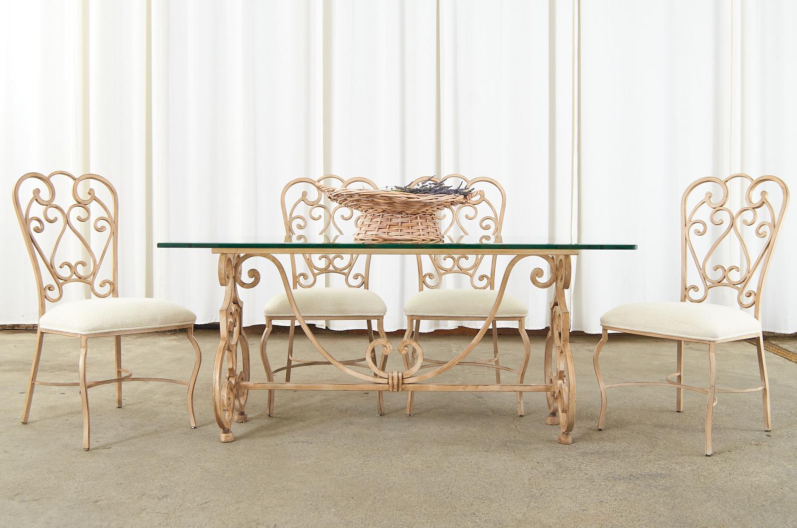 Distinctive patio and garden dining table made in the Spanish colonial revival style. The table features a thick, solid iron frame having a painted finish with an intentionally aged patina. Made in Montebello, CA. Matching chairs are also available.