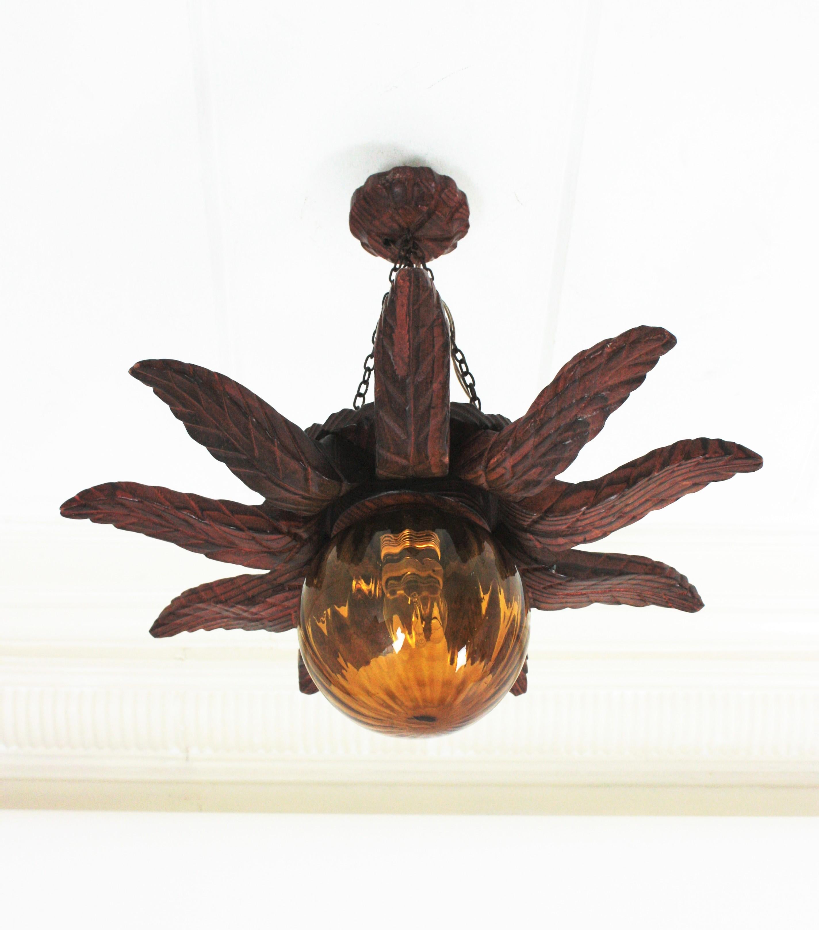 Spanish Colonial Sunburst Light Fixture in Carved Wood with Amber Glass Globe In Good Condition For Sale In Barcelona, ES