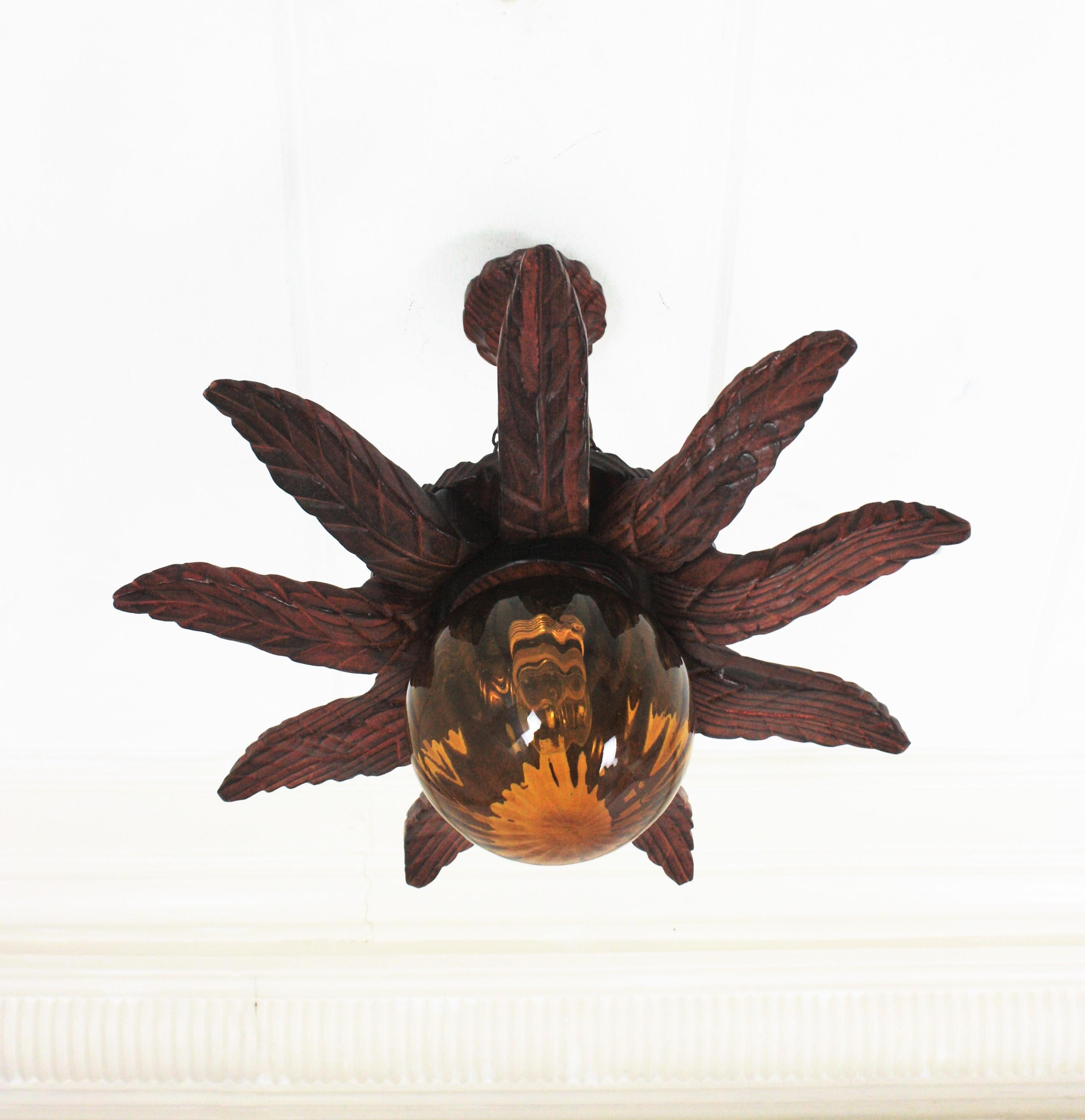 20th Century Spanish Colonial Sunburst Light Fixture in Carved Wood with Amber Glass Globe For Sale