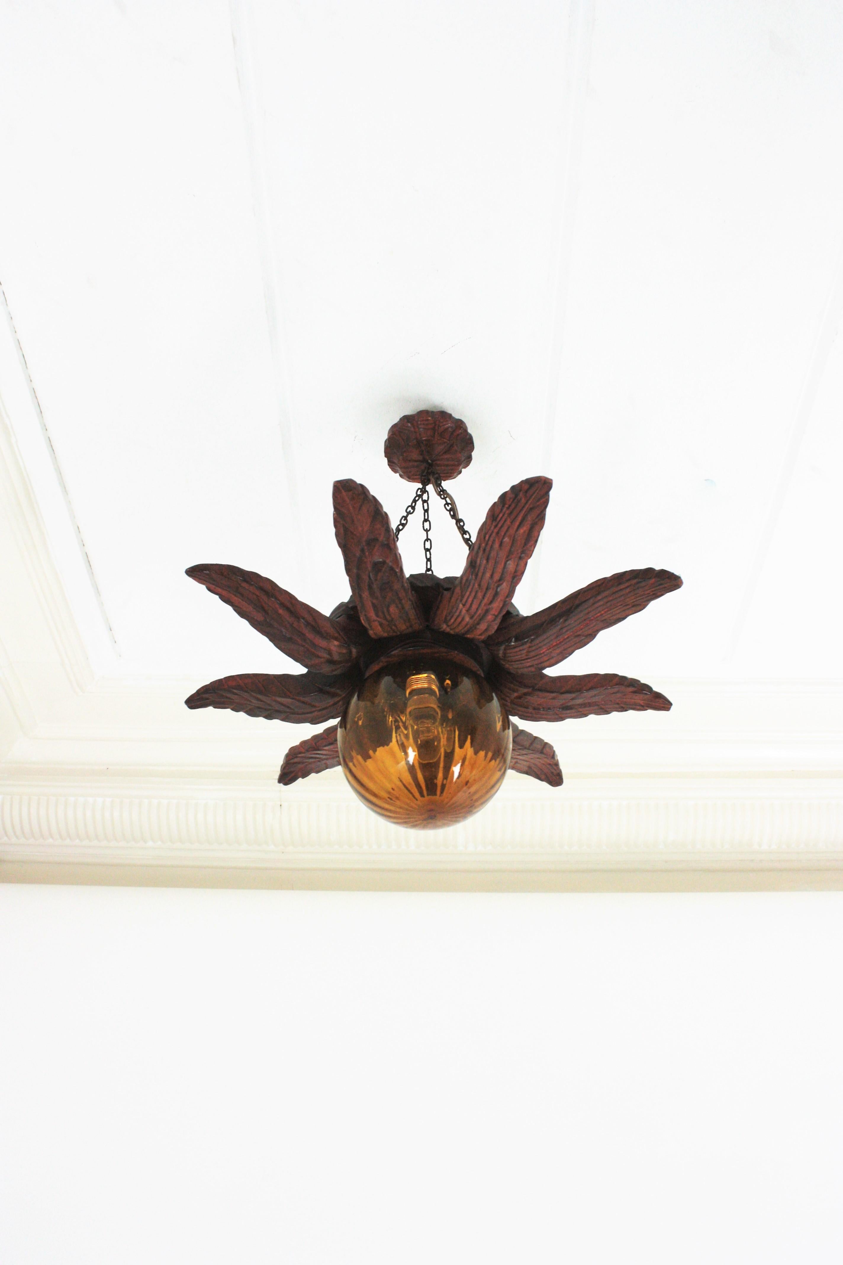 Spanish Colonial Sunburst Light Fixture in Carved Wood with Amber Glass Globe For Sale 1