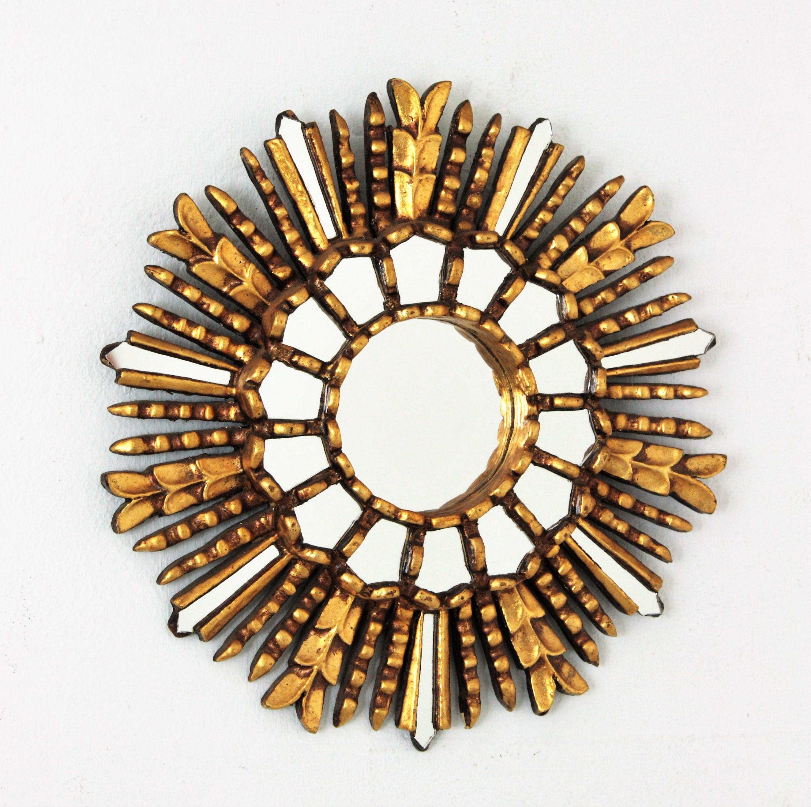 Spanish Colonial style gilt wood sunburst mirror with mirror insets in the frame, 1950S-1960S
This lovely small sunburst mirror has a layer of mosaic small mirrors surrounding the central glass and alternating rays with mirror inlays in sunburst