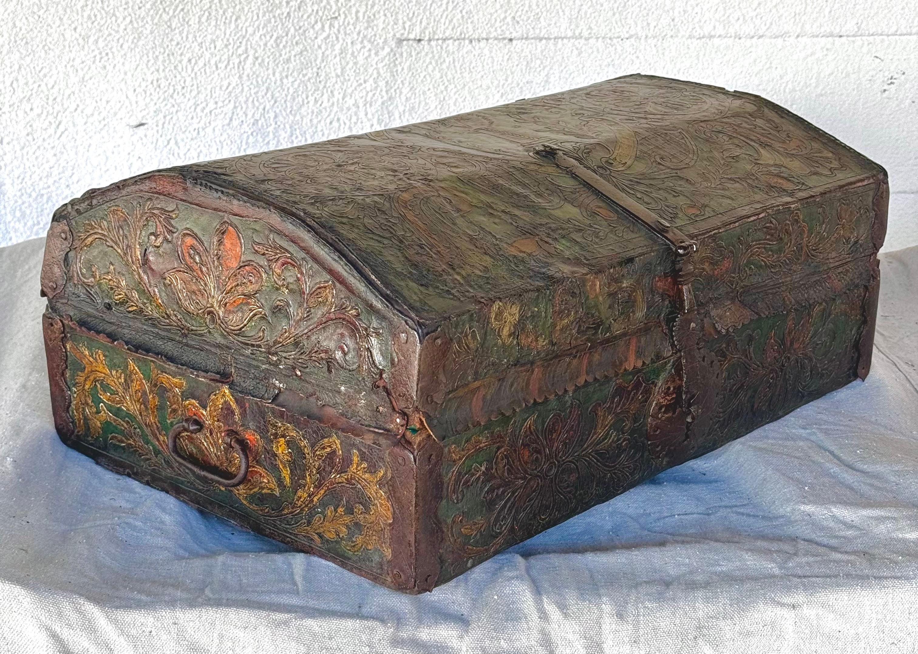 18th century Spanish Colonial tooled leather trunk/chest. Chest features an embossed floral motif in subtle colors of green, brown, and yellow with a decorative hand forged iron latch and fabulous center lock plate. Possibly Peruvian.