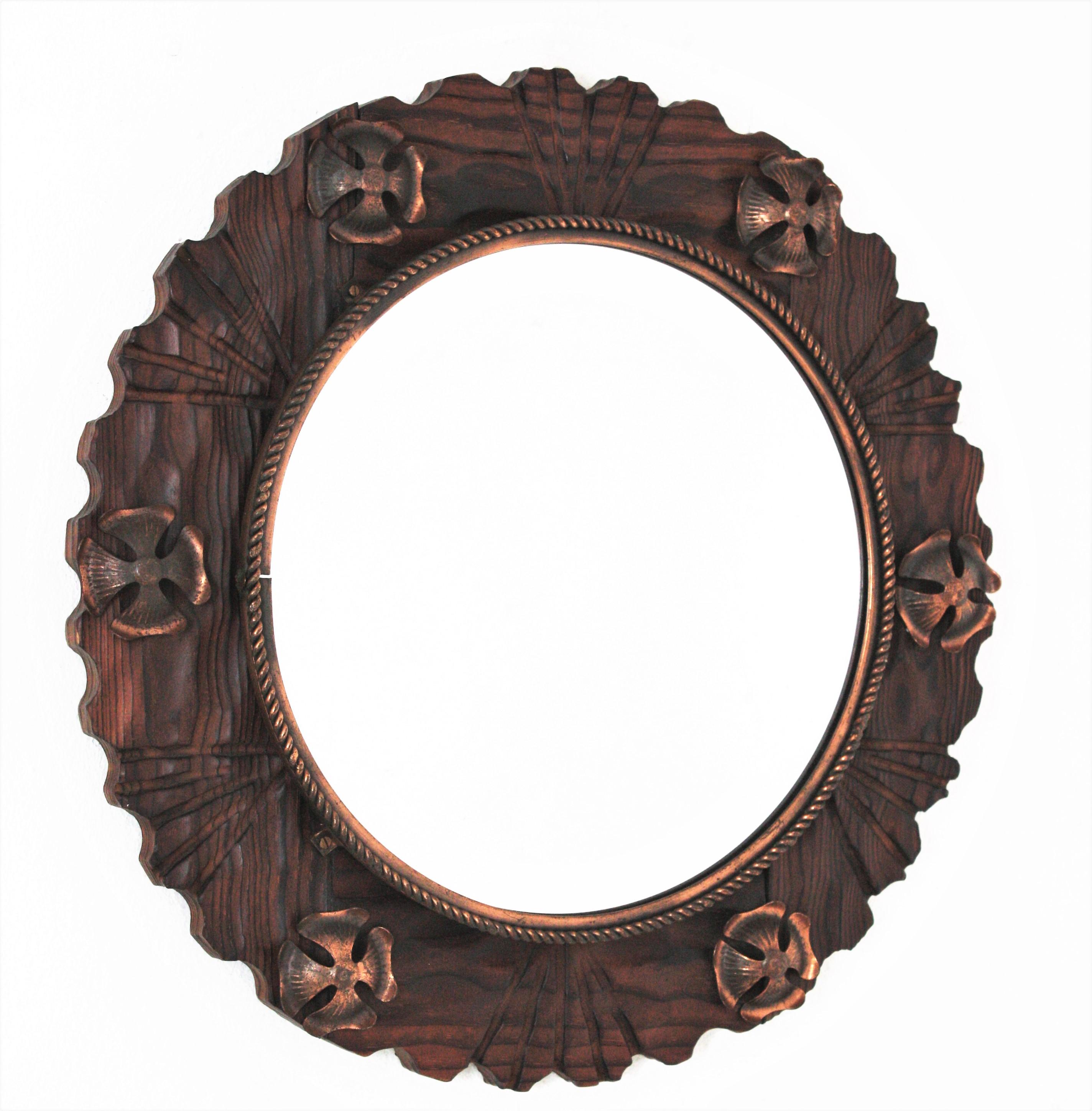 Hand carved pine wood round wall mirror with copper flower details, Spain, 1940s.
This wall mirror features a wooden scalloped frame surrounding a central round glass with a twisted copper pattern. Turned wood details and stripes decorations as