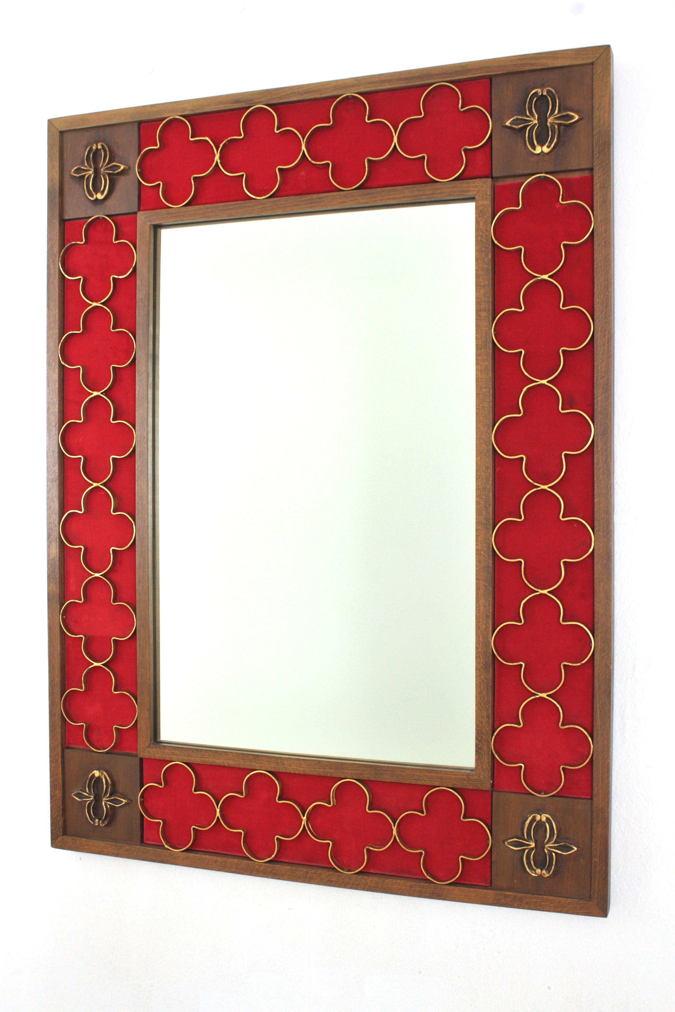 Large Rectangular Spanish Revival Mirror with Gilt Iron Rosettes, Spain, 1950-1960.
Beautiful rectangular frame with carving details on the corners. It has an inset frame with a red background and a decorative attached pattern of gilt wrought iron