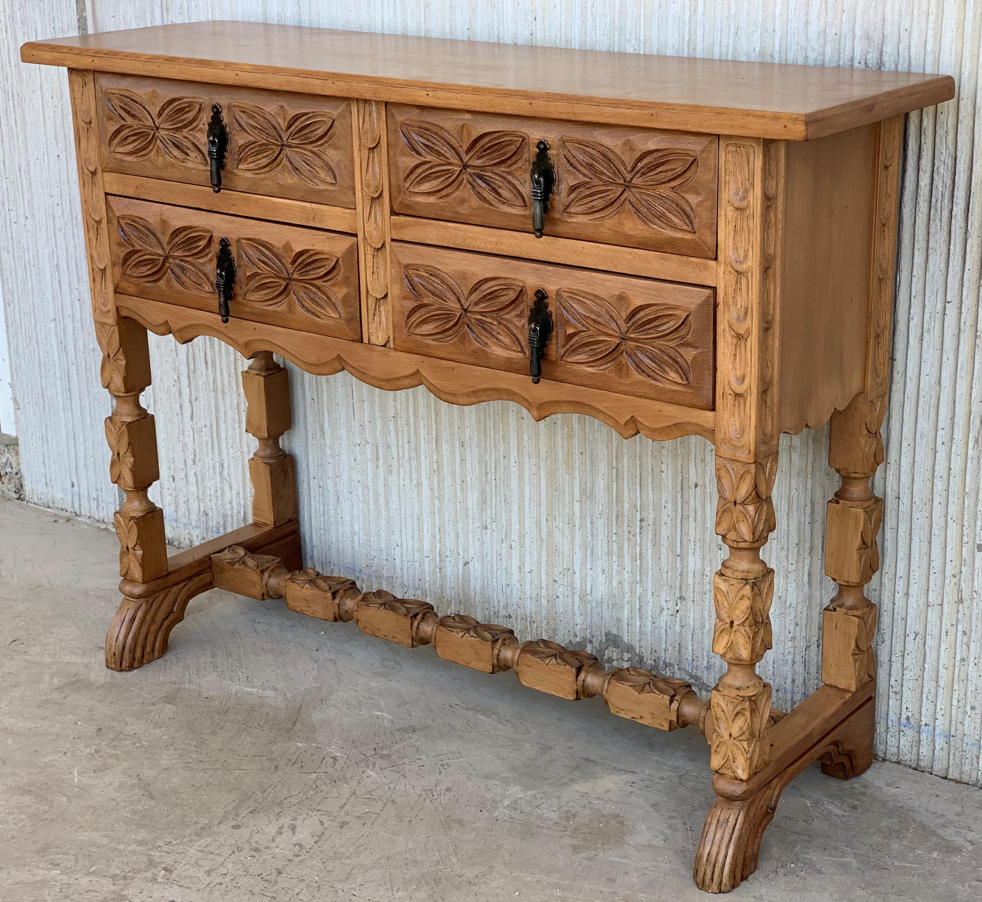 This Spanish late 19th century features a beautiful one plank rectangular top over four carved drawers. Each drawer, featuring slightly different hardware, is adorned with geometrical motifs. Rosettes are carved between the drawers and each drawer