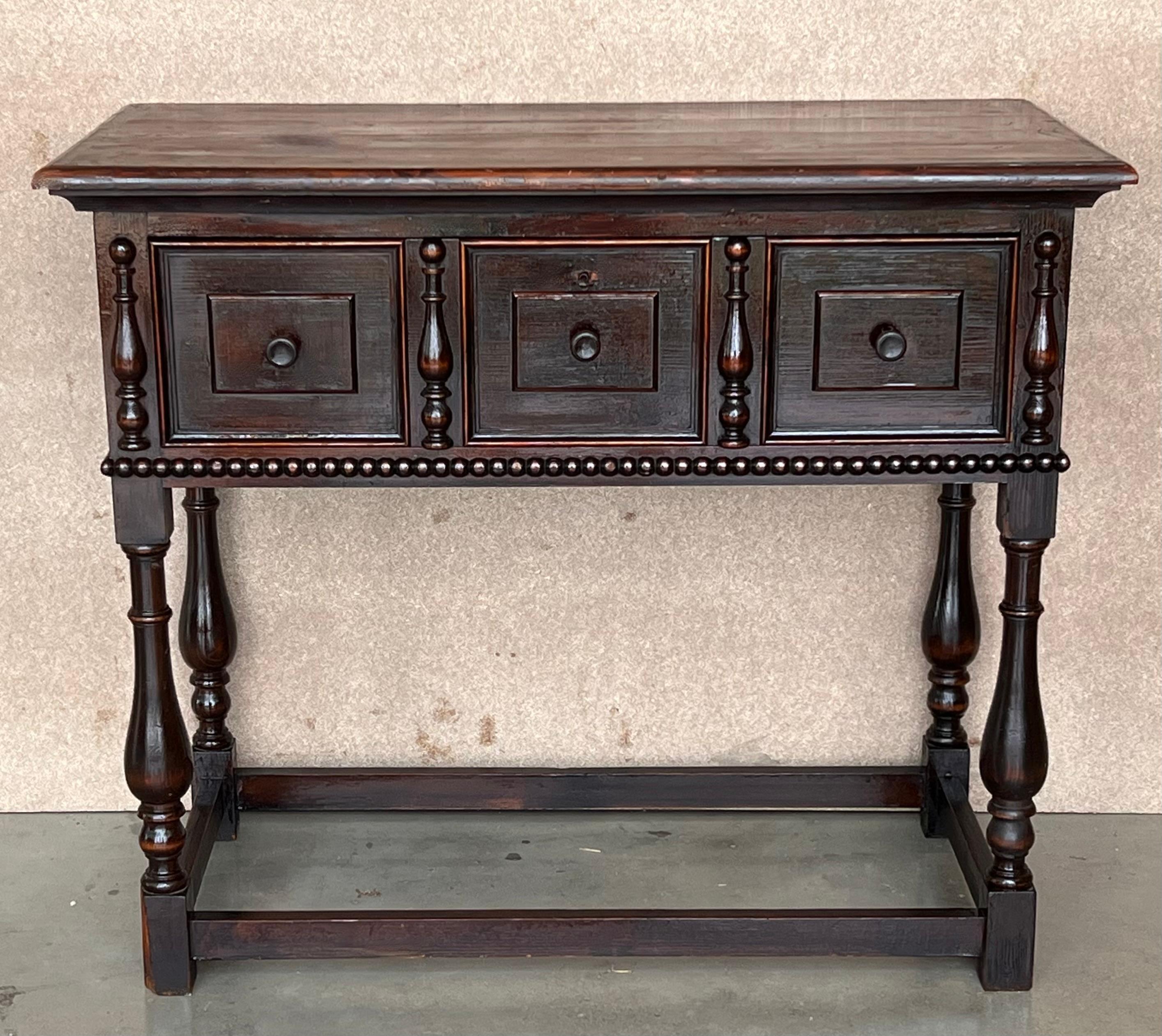 This large Spanish late 19th century features a beautiful one plank rectangular top over a carved drawer featuring slightly different hardware, is adorned with geometrical motifs and columns with their original handmade drop pulls
The apron is