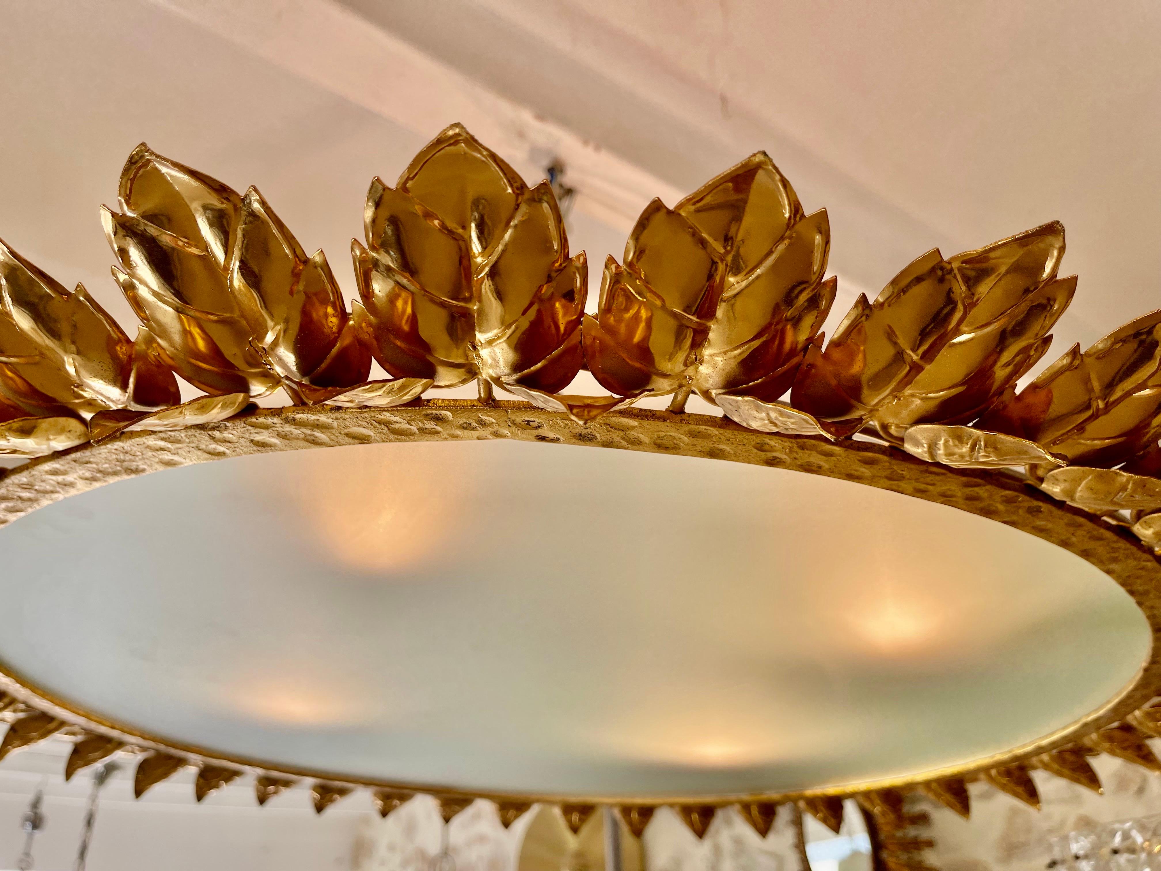 Gran lámpara de corona española en metal dorado y cristal esmerilado, España, años 1970. Marco o colgante de hierro dorado antiguo de mediados de siglo con motivos de hojas de laurel que rodean un difusor central de cristal esmerilado. Hecho a mano