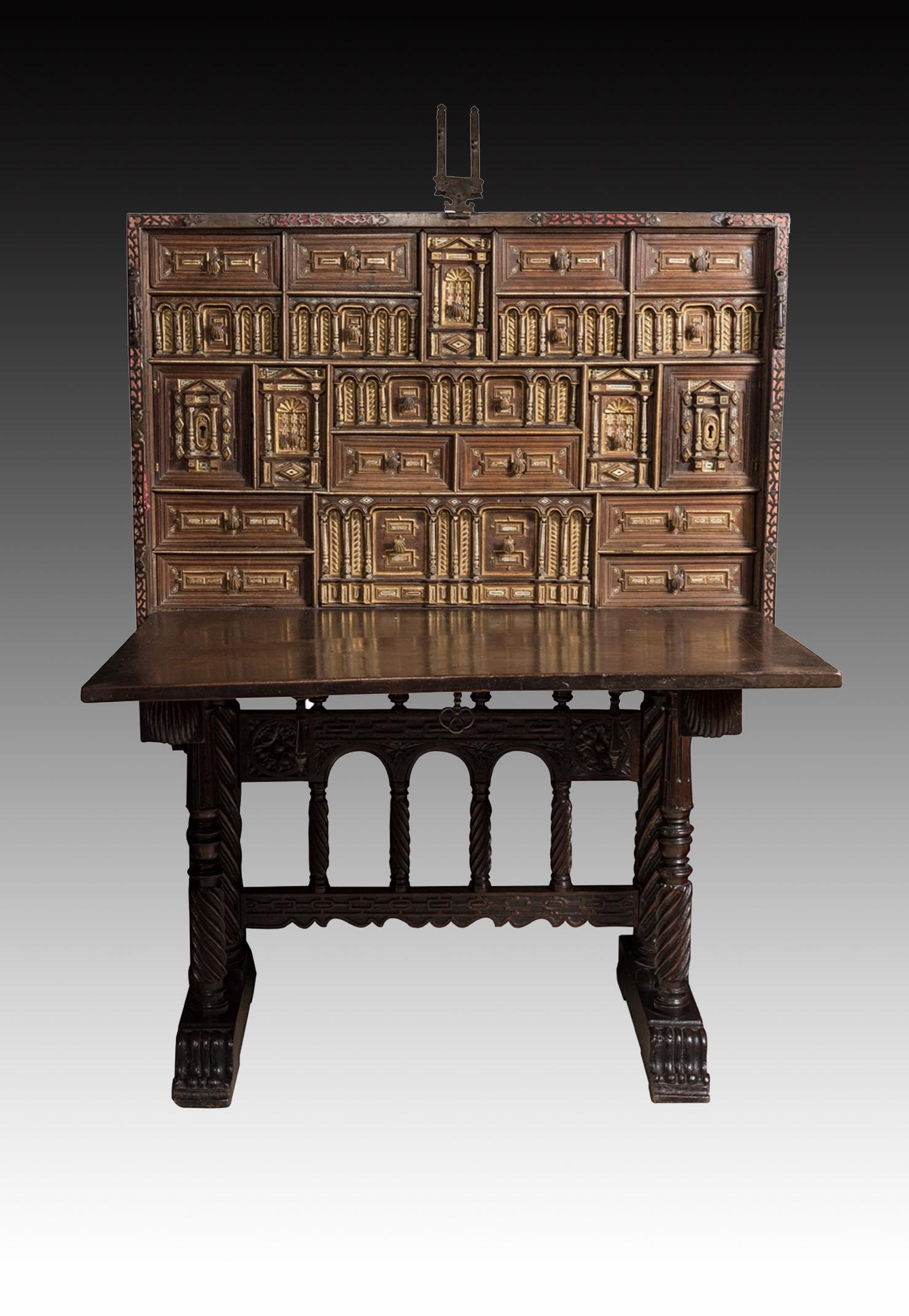 Spanish desk (“bargueño”). Walnut, etc. 17th century (support “de pie de Puente” or “bridge-shapped”, 19th century). 
It has restorations; later metal fittings.
“Bargueño” type Spanish desk with folding cover, which has been decorated on the