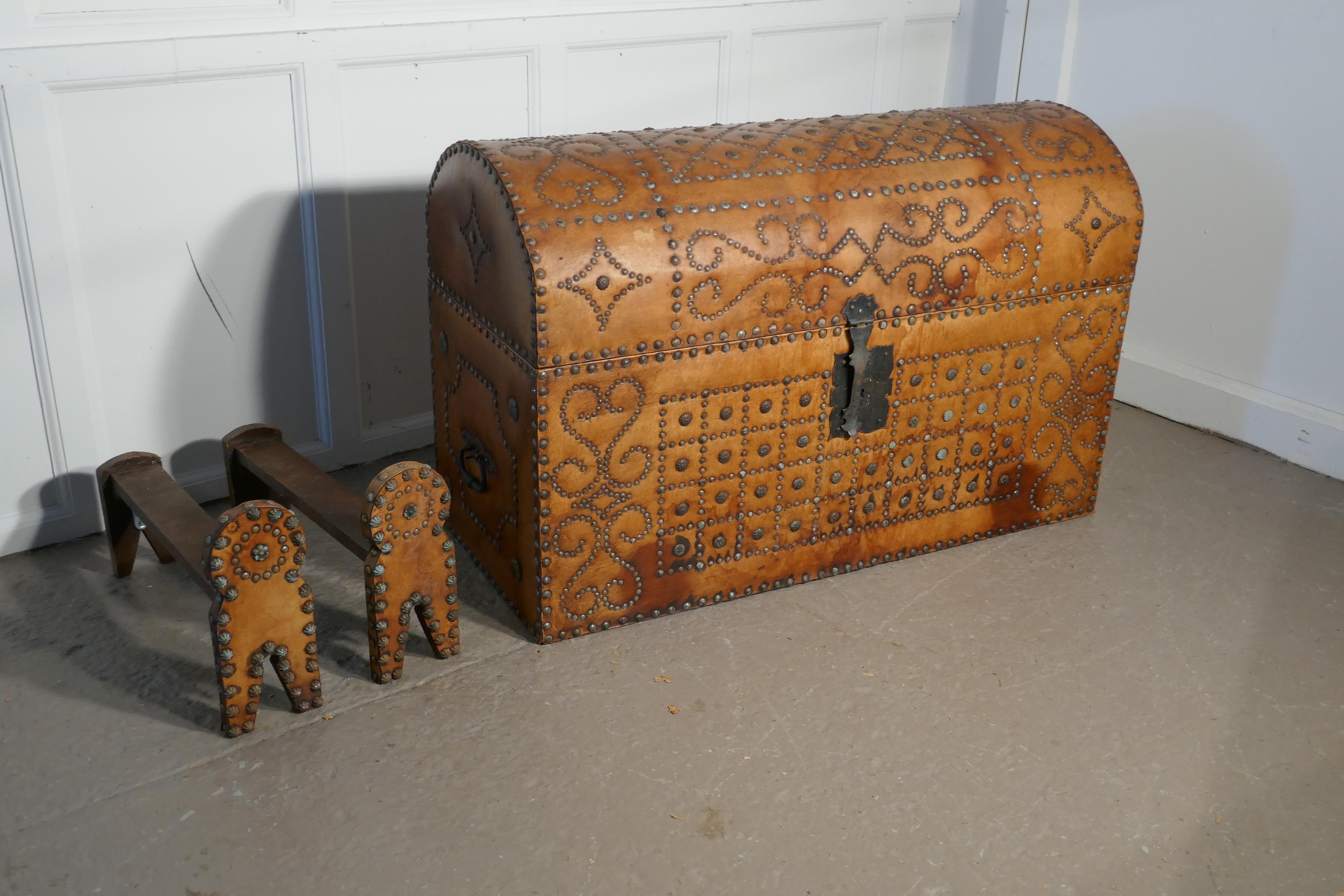 Spanish dome top leather brass studded marriage chest or travel trunk

This is a very attractive piece, it has a dome top and it is covered in superb quality thick Tan leather with an elaborate brass stud work decoration. 
 
The trunk is lined
