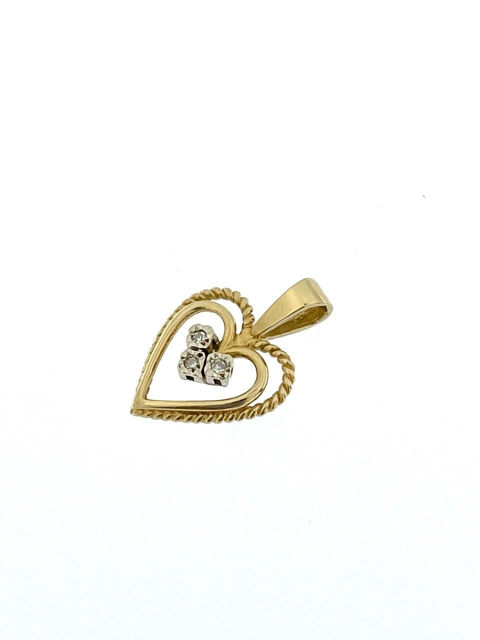 The Spanish Double Heart Pendant in Yellow and White Gold with Diamonds is a romantic piece of jewelry that showcases intricate craftsmanship and elegance. Crafted from 18-karat yellow and white gold, this pendant features a unique design with two
