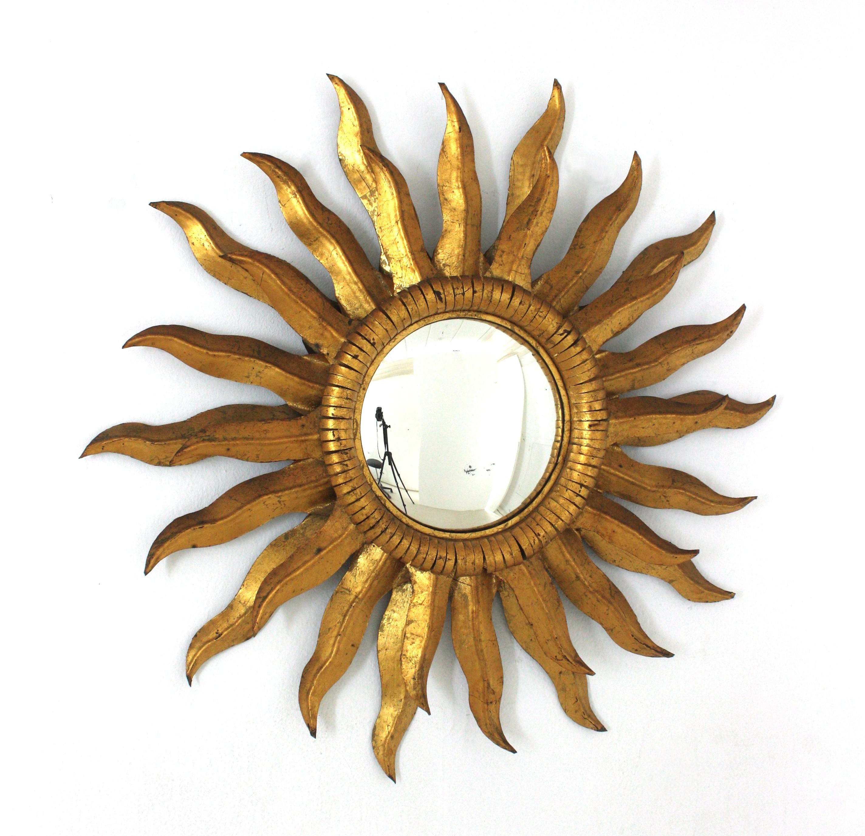 Hand-Crafted Gilt Metal Convex Sunburst Mirror, Iron, Gold Leaf
Eye-catching Mid-Century Hollywood Regency sunburst mirror in gilt iron, Spain 1950s
Double layered frame, convex glass and gilded finish in gold leaf. It has a glamourous patina