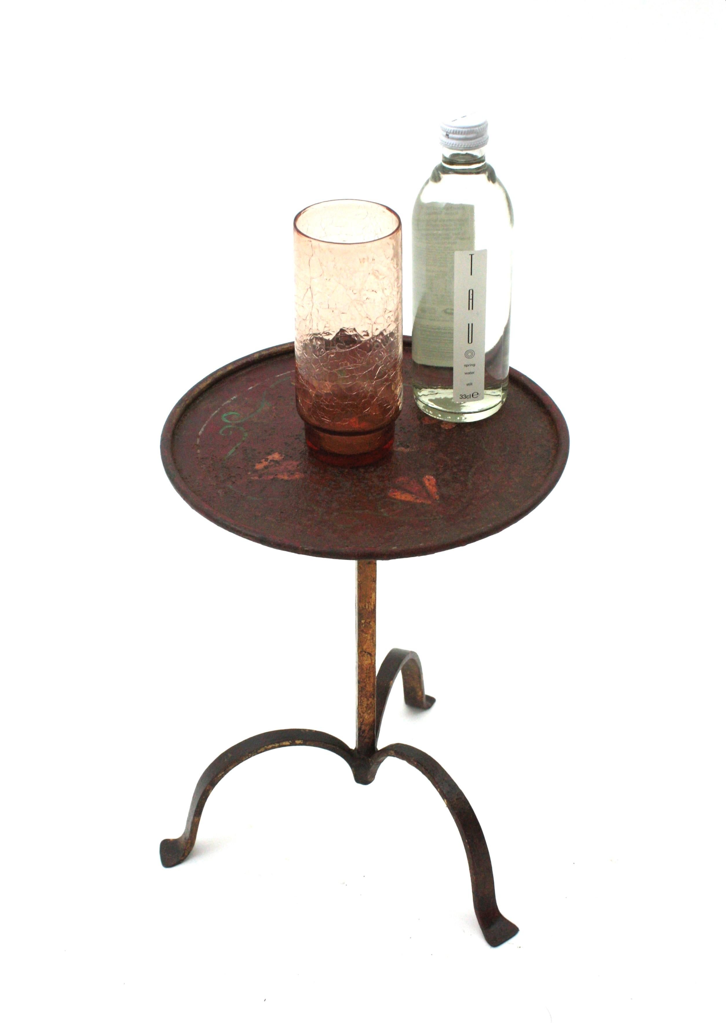 Spanish gilt wrought iron drink / cocktails table with polychromed top, Spain, 1940s.
Handcrafted in wrought iron with gilt finish on the base. The round top has hand-painted floral decorative details and a terrific aged patina in redish color with