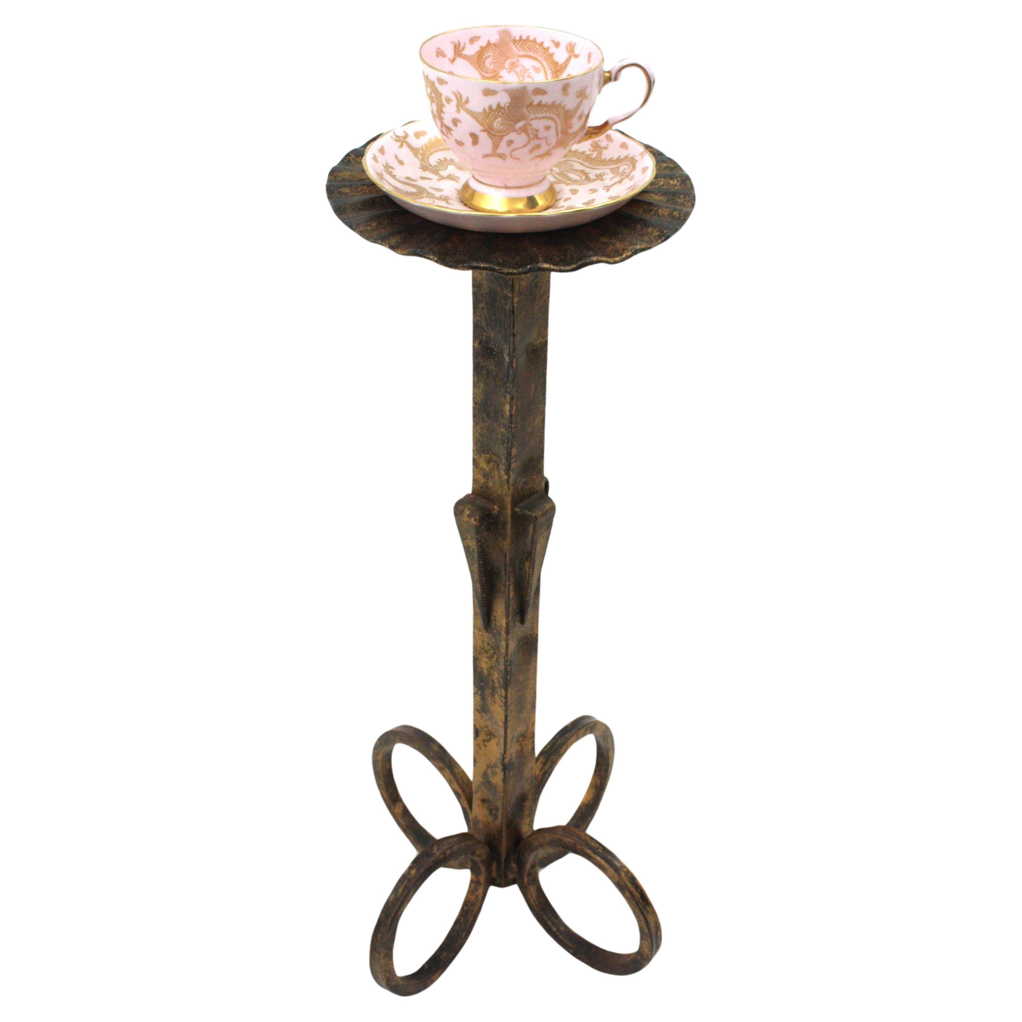 Spanish wrought iron floor ashtray or drinks / cocktails table standing on a looped base, Spain, 1950s.
Handcrafted in wrought gilt iron. The scalloped top stands up on a four loop base 
Terrific parcel-gilt finish and foliage decorations on the