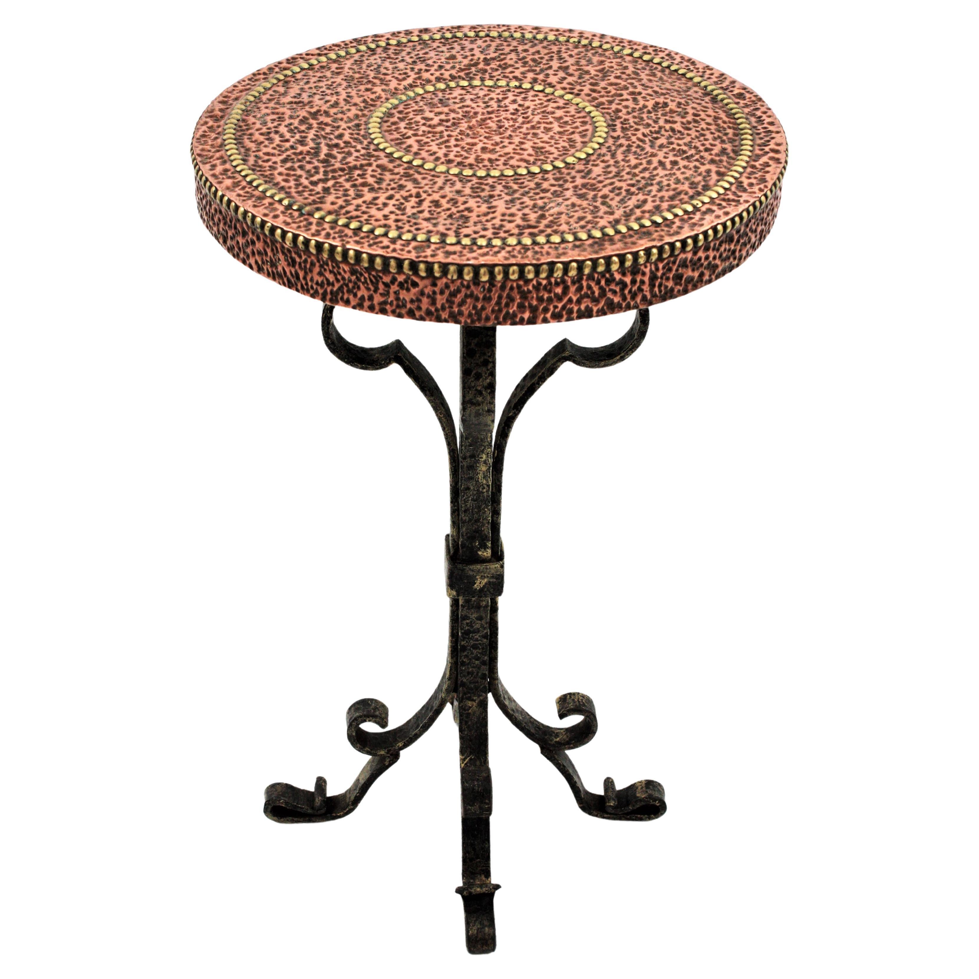 Mesa Martini / mesa auxiliar de cobre martillado y hierro con tablero redondo y base de cuatro patas, España, años 30.
Este gueridón / pedestal tiene una gruesa tapa redonda martillada a mano con un bonito y rico trabajo de martillado y tachuelas de