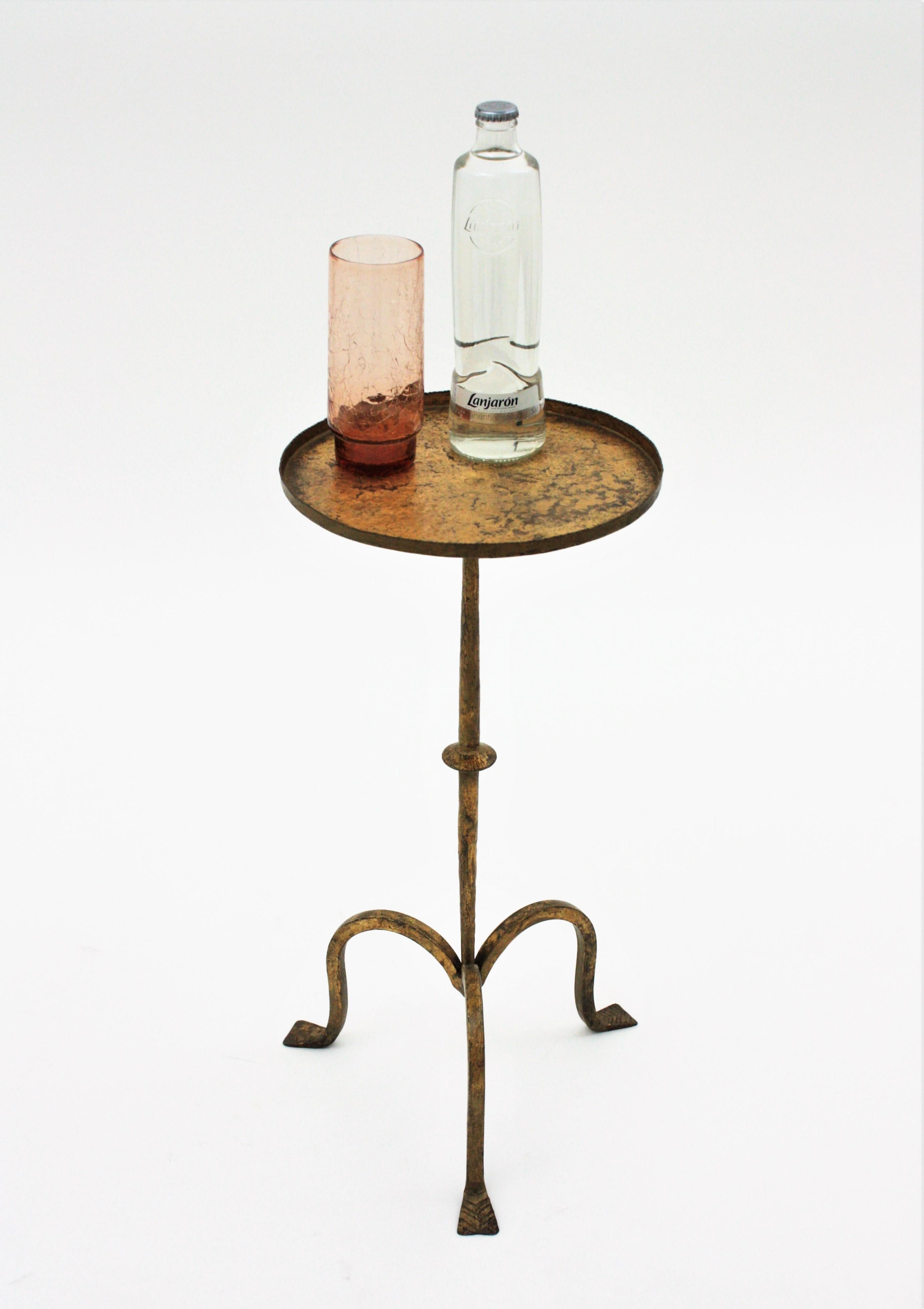Beautiful hand-hammered gilt wrought iron occasional drinks table on a tripod base, Spain, 1940s
Entirely made in hand forged iron. Original gold leaf gilding and beautiful patina
It has a clean design inspired in Gothic style. The round top has a