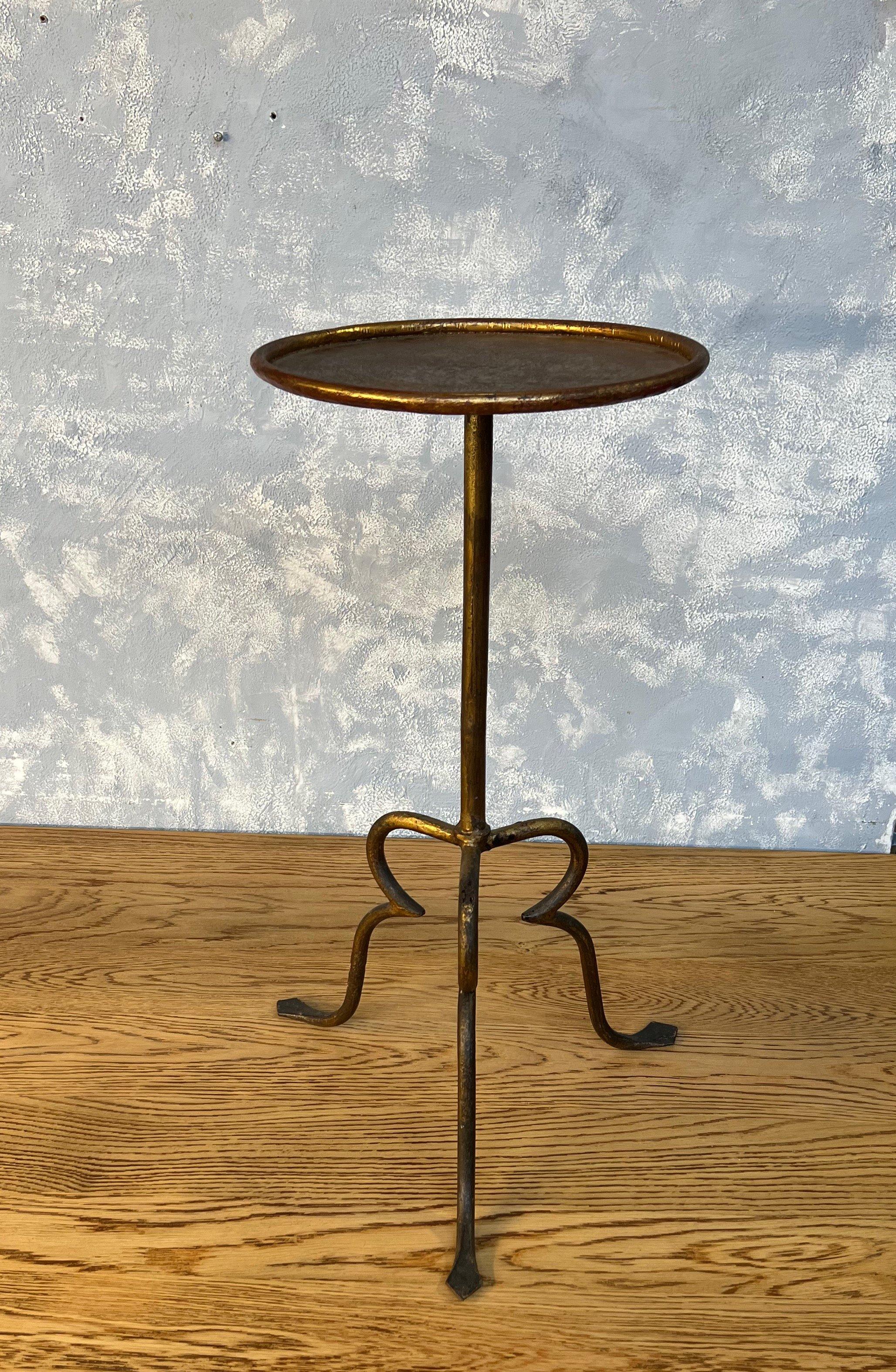 Cette table à boissons unique, reposant sur une base tripode, offre un design inhabituel mais esthétique. La table présente une finition dorée originale appliquée à la main avec des nuances plus foncées, ce qui lui confère un aspect riche et