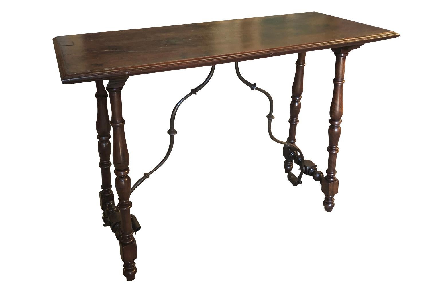 A very charming early 19th century console table from the Catalan region of Spain. Beautifully constructed from stunning walnut and hand forged iron stretchers. Terrific patina.