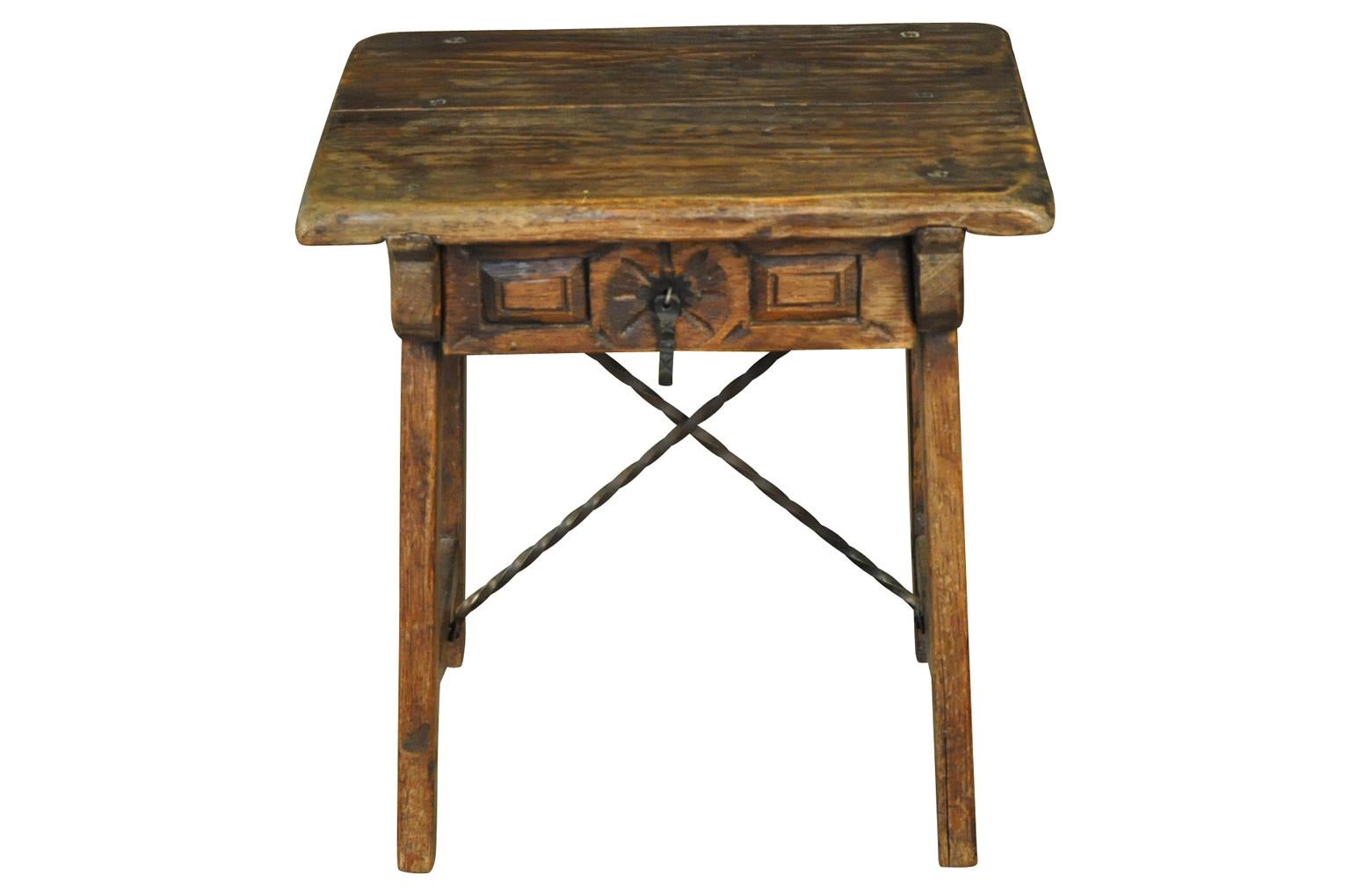 A very charming early 20th century side table from the Catalan region of Spain. Sturdily constructed from richly stained oak with iron stretchers. A charming accent piece for a casual interior.