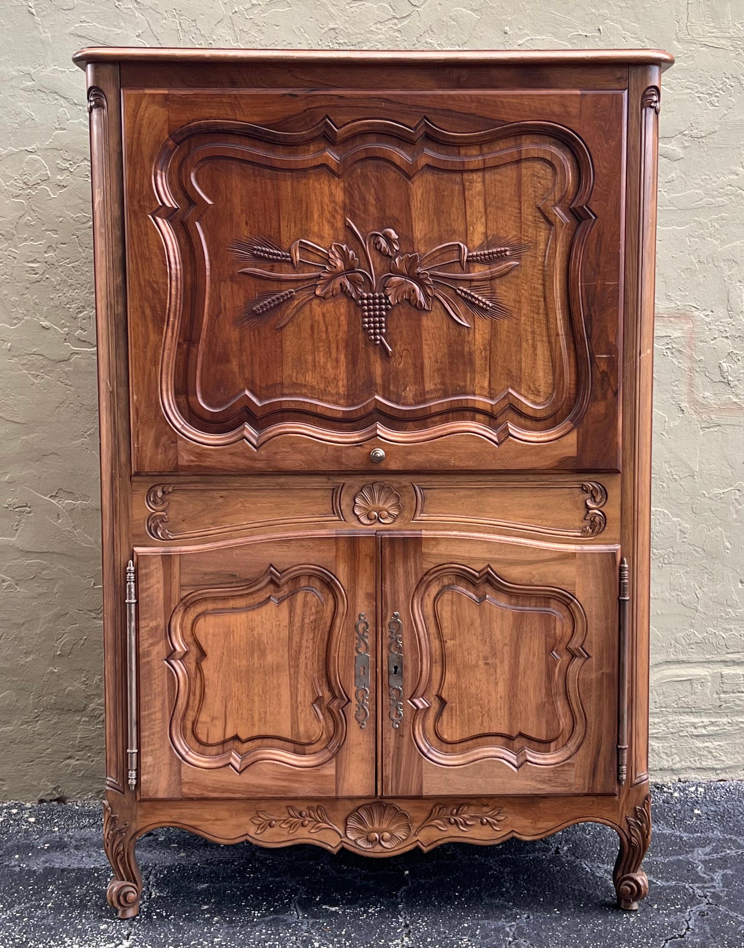 Mid 20th century walnut Spanish front cabinet with molded carvings and two compartments, the hight compartment has a sliding door that can be hidden easily to open the space and the low part has two doors with a big interior space.



