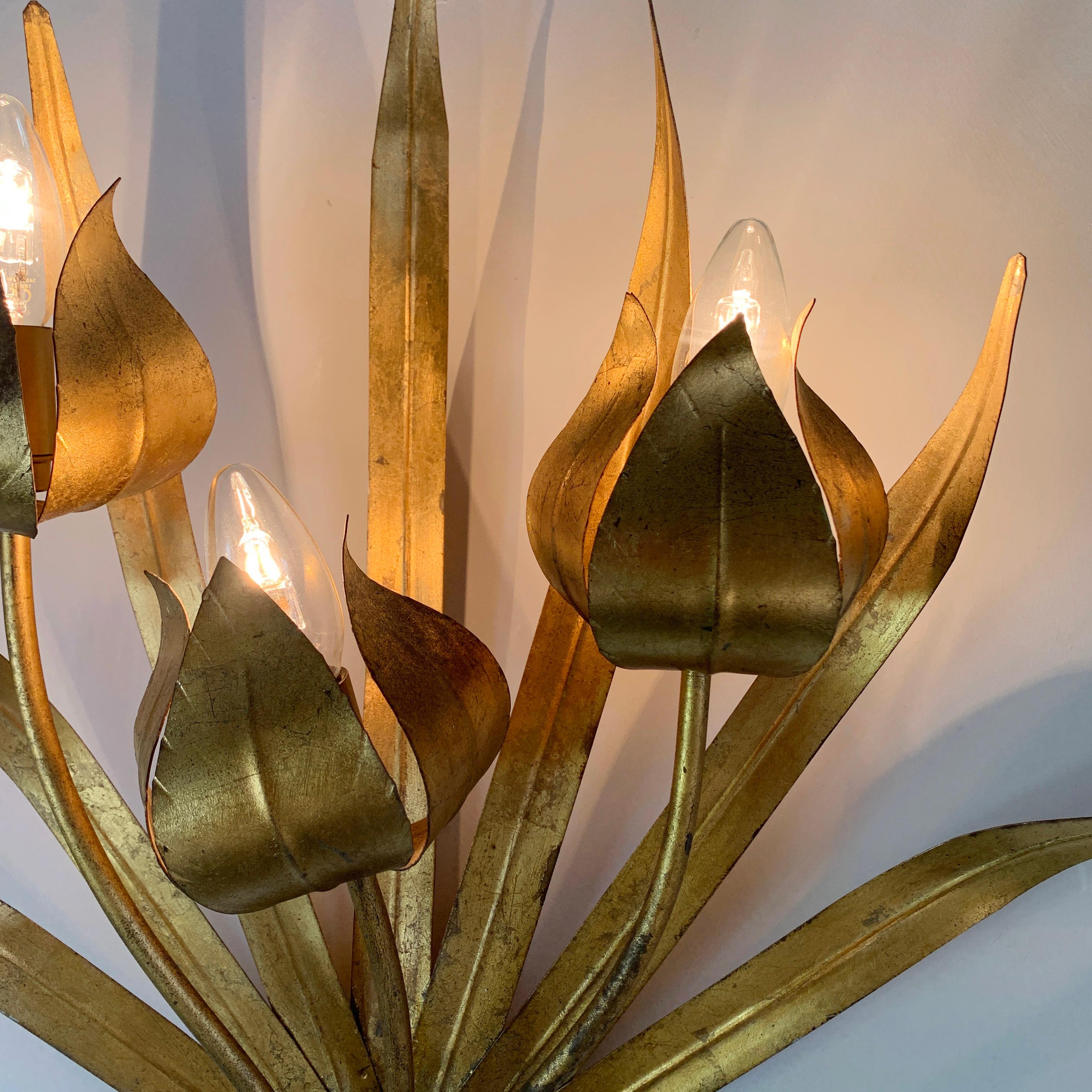 A wonderful wall light by the Spanish maker Ferro Art, the gilt gold metal in the form of 7 wide leaves, the 3 lamp holders sit within the flower head decorations. As can be seen in the images, this is a stunning looking light, and looks even better