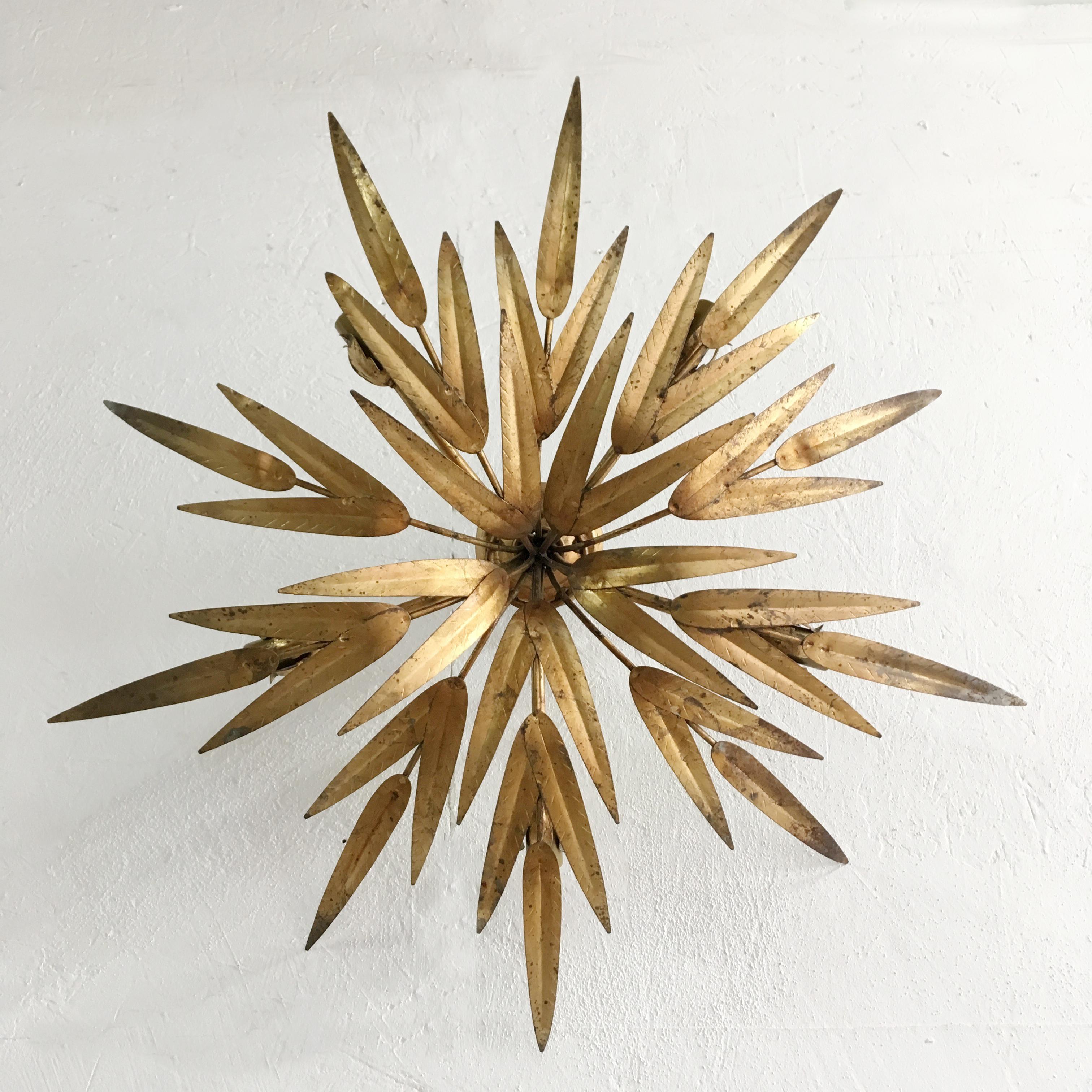 Spanish palm leaf flush ceiling light
Attributed to 'Ferro' Spain
circa 1950s
The light has a fixed ceiling rose so the lamp sits close to the ceiling
The gold leaf covered metal leaves reach out in 10 branches
Behind the branches of palm