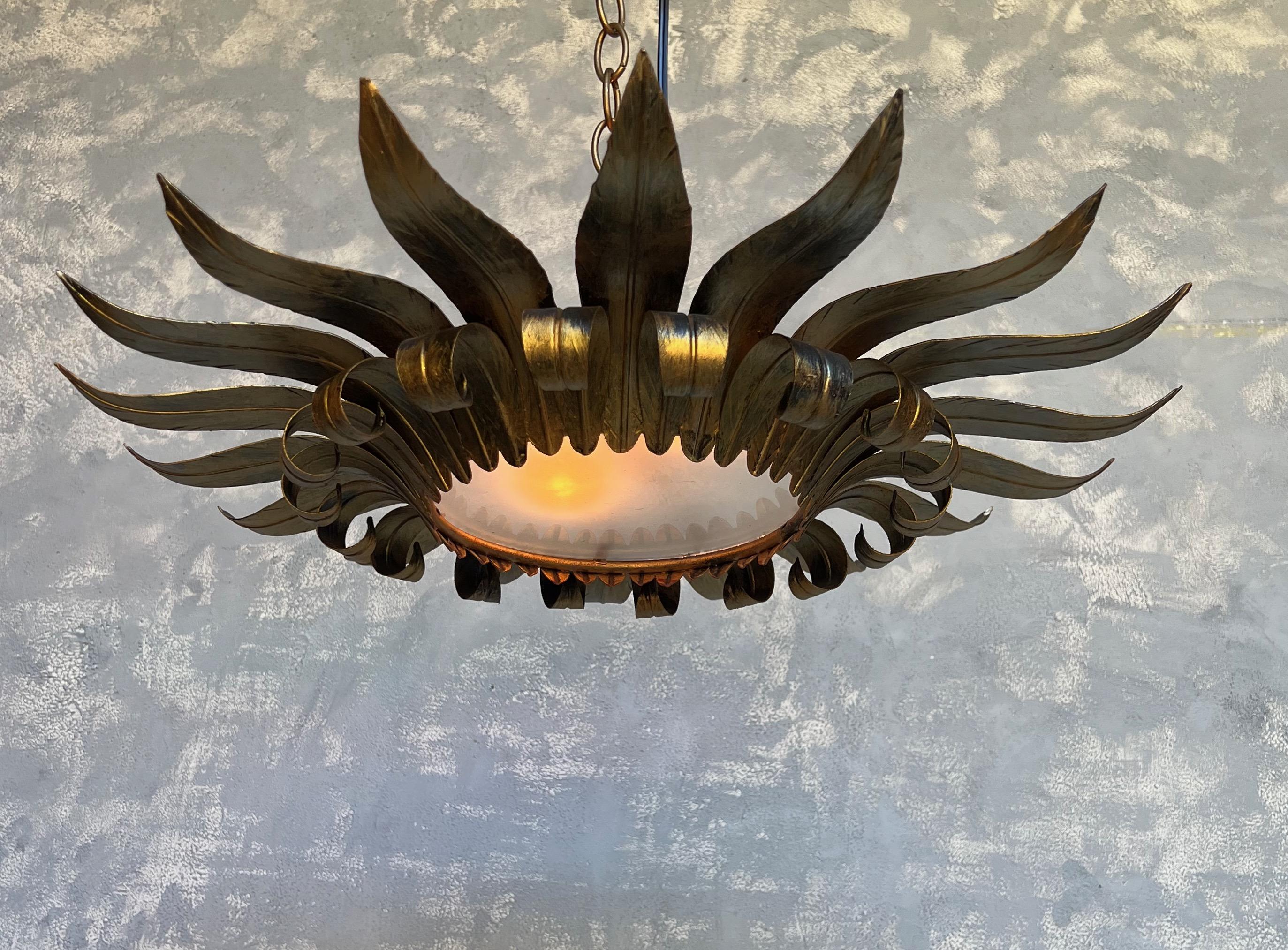 A large flush mount ceiling fixture with double tiered leaf patterns, the upper tier being pointed out while the lower tier curls under. The hand applied finish has a rich gold patina with darker under tones showing through.
This fixture has been