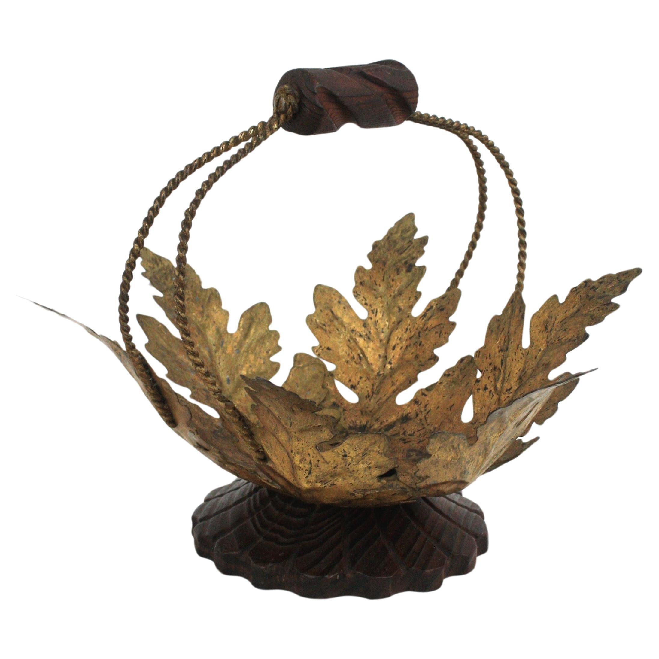 Mid-Century Modern gilt iron and carved wood basket centerpiece / fruit bowl, 1950s-1960s
Handcrafted in Spain at the Mid-20th century period in the style of Spanish Colonial. 
Eye-catching centerpiece featuring gilt iron leaves standing on a carved