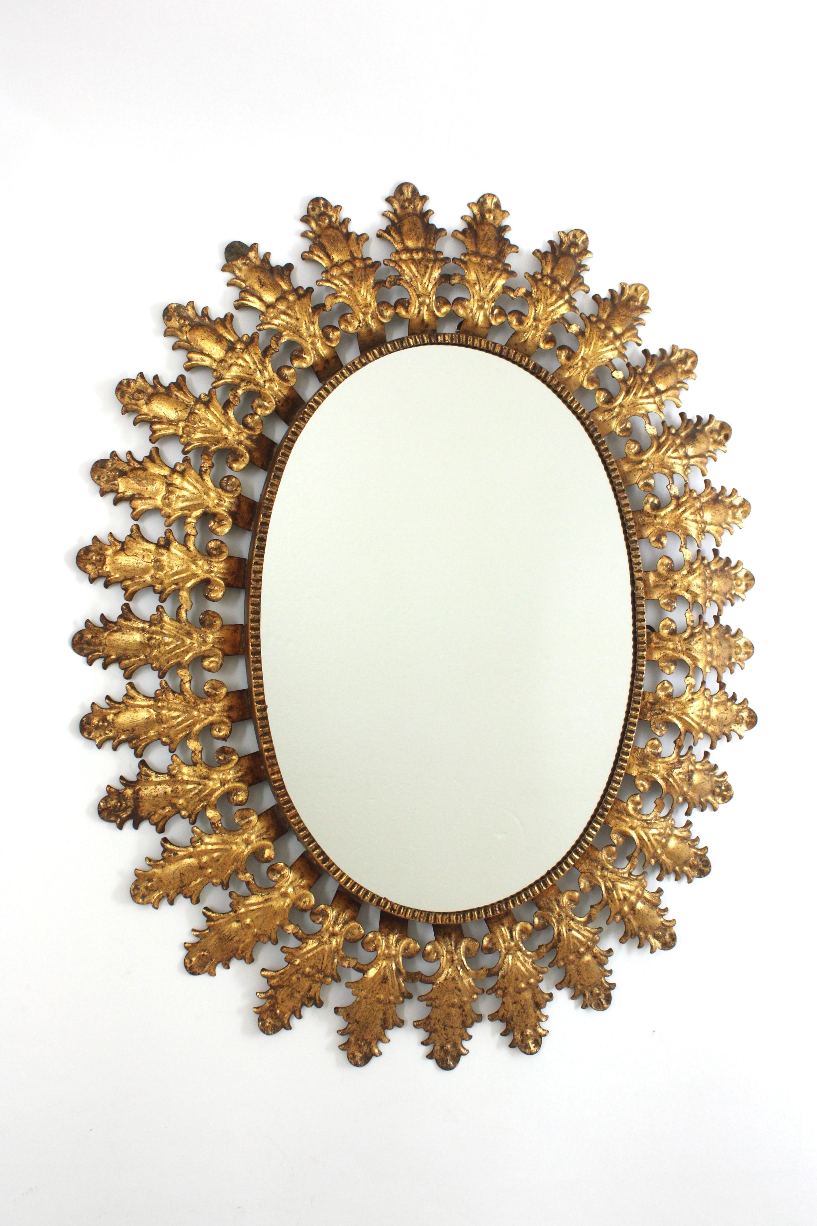 Miroir espagnol ovale, feuille d'or, métal doré, Espagne, années 1950.
Cet élégant miroir soleil présente un cadre de feuilles avec de jolis détails entourant le verre central. Son design combine le style Hollywood Regency et des accents baroques